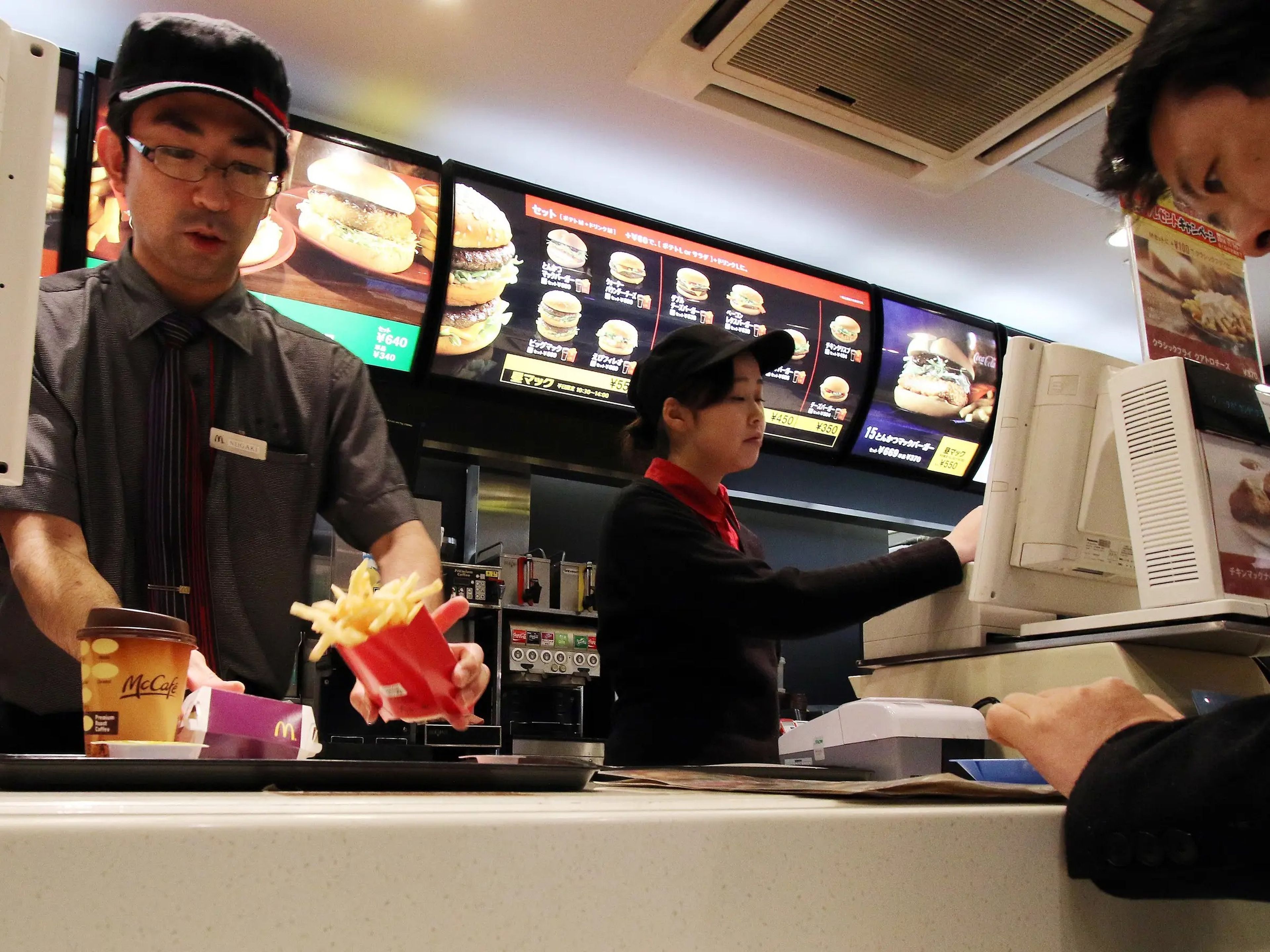 An employee serves french fries to a customer at a McDonald's restaurant in Tokyo.
