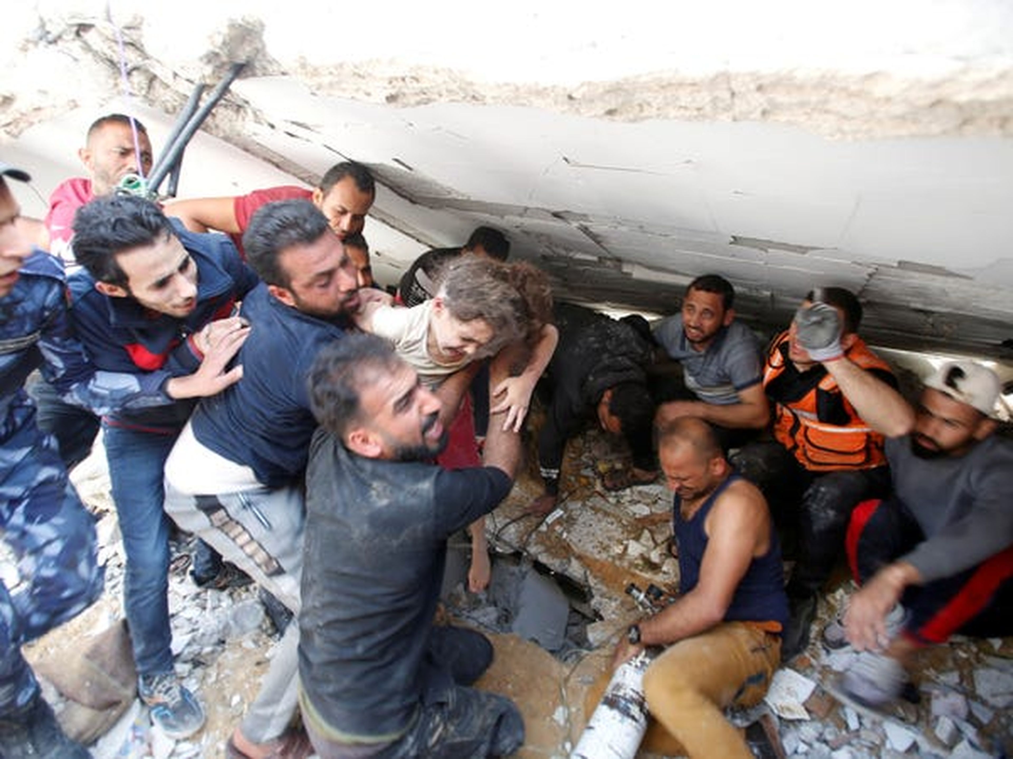 Los equipos de rescate cargan a Suzy Eshkuntana, de 6 años, mientras la sacan de los escombros de un edificio en el lugar de los ataques aéreos israelíes en la ciudad de Gaza el 16 de mayo.