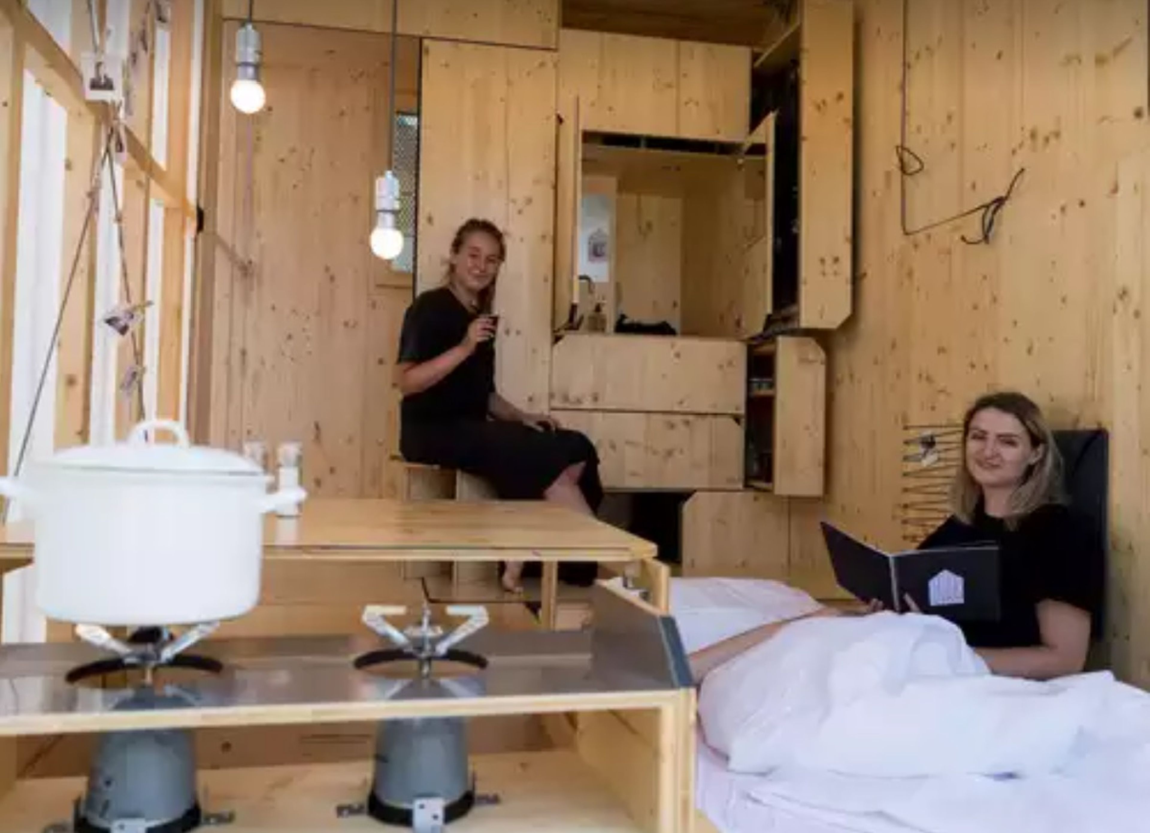 Las estudiantes de arquitectura Sarah Ullmayer y Sophie Kany sentadas en su pequeña casa en el campus de la Bauhaus en Berlín.