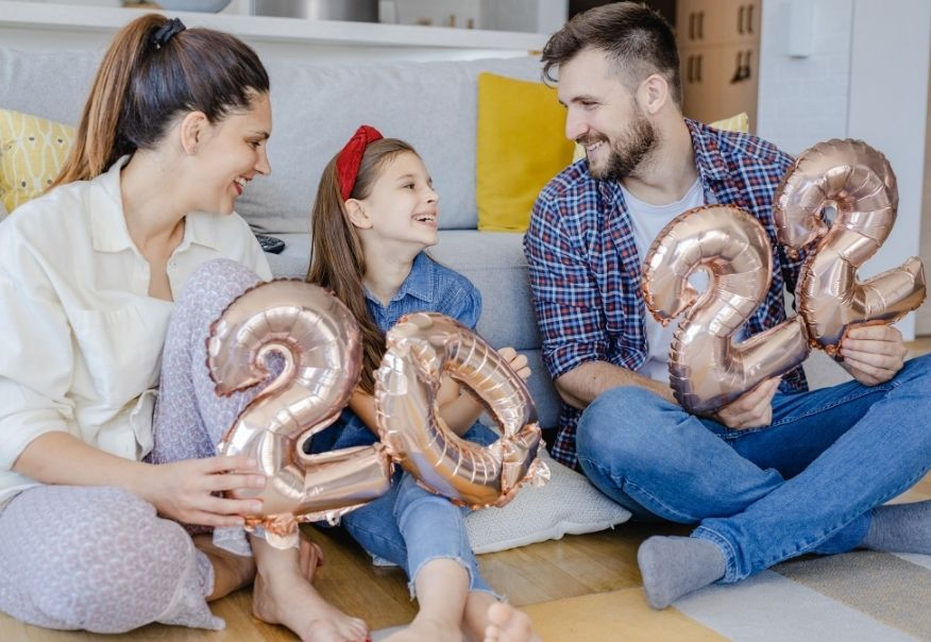 Una familia con globos formando un 2022.