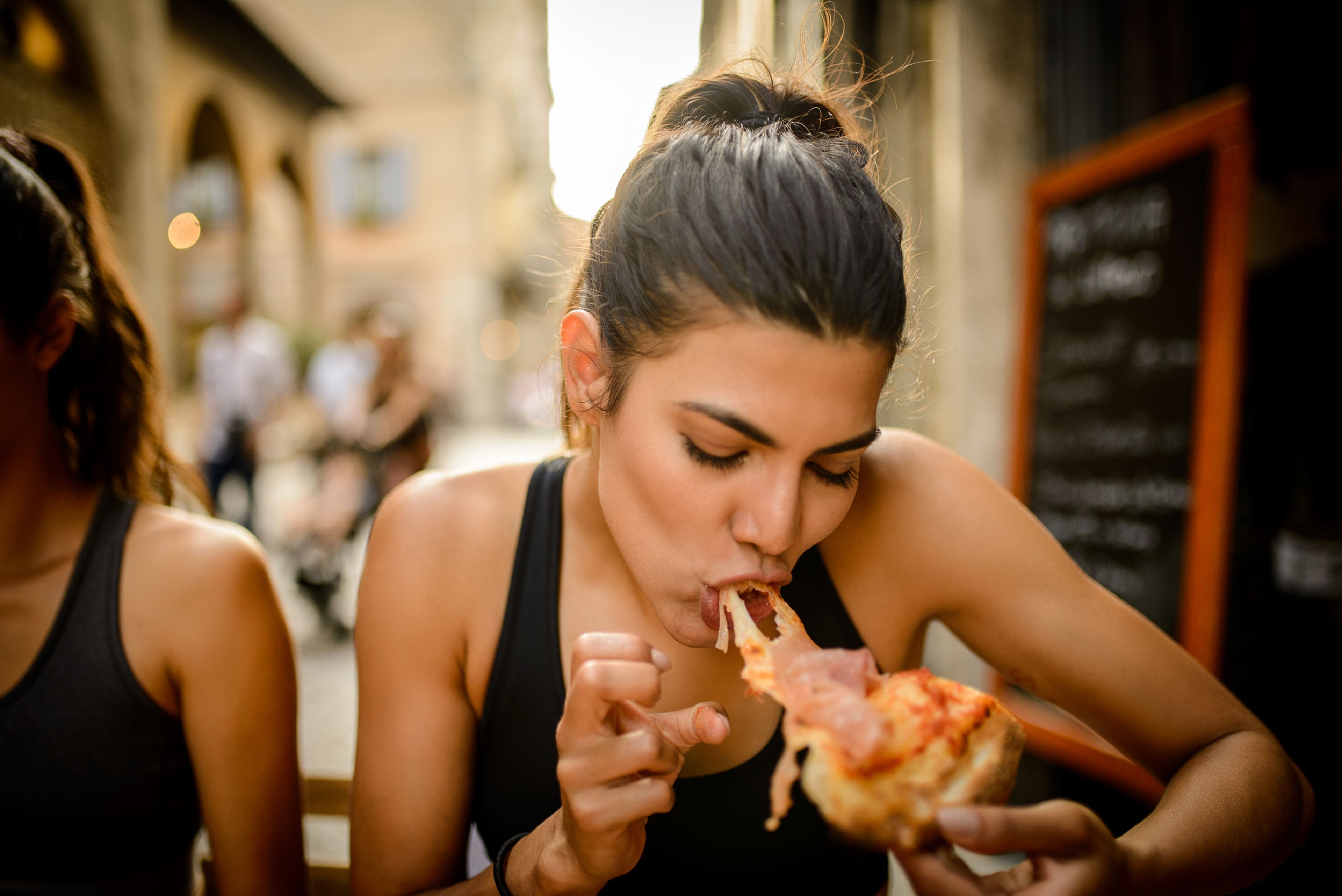 Una mujer come pizza.