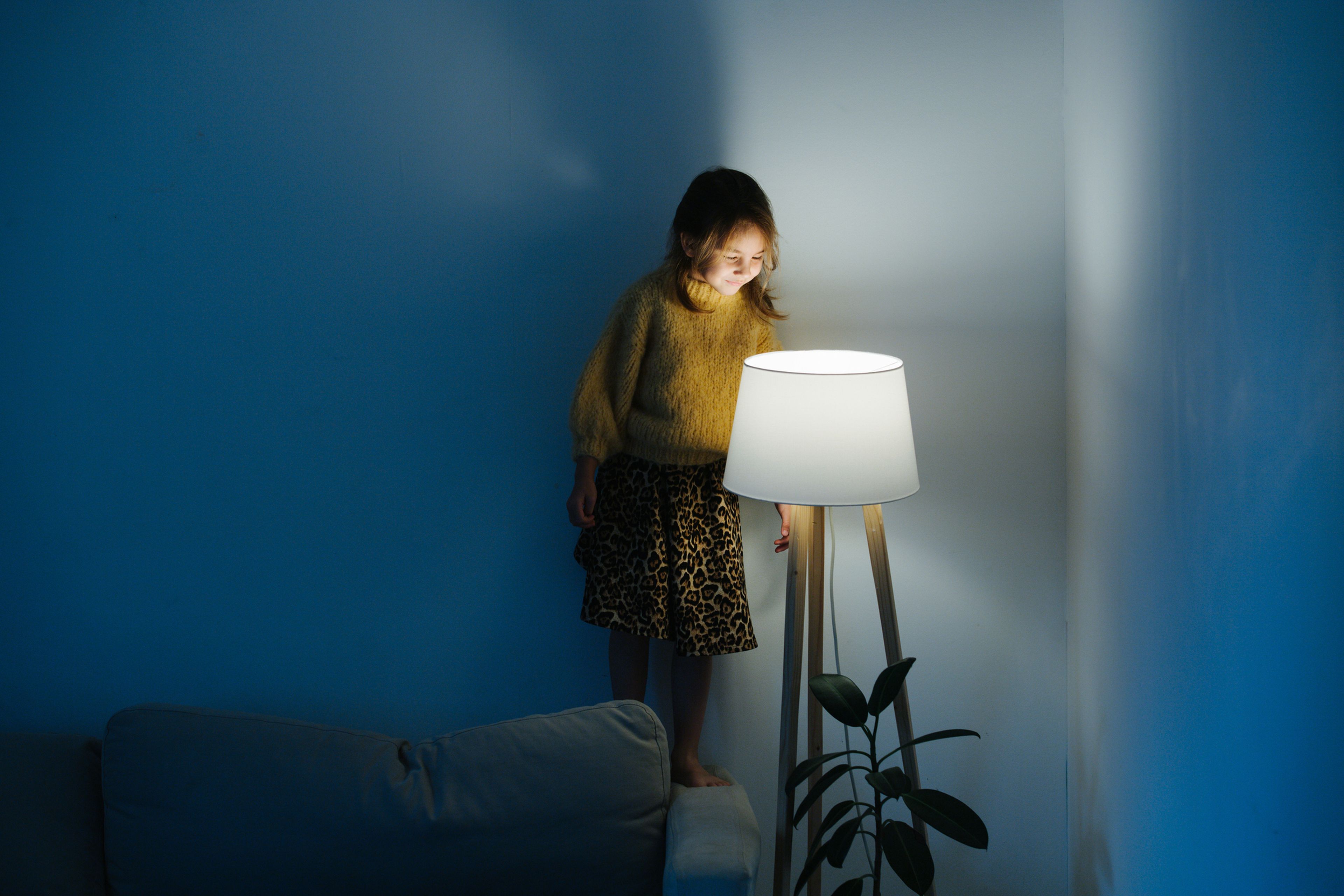 Una niña mira una lámpara desde arriba.