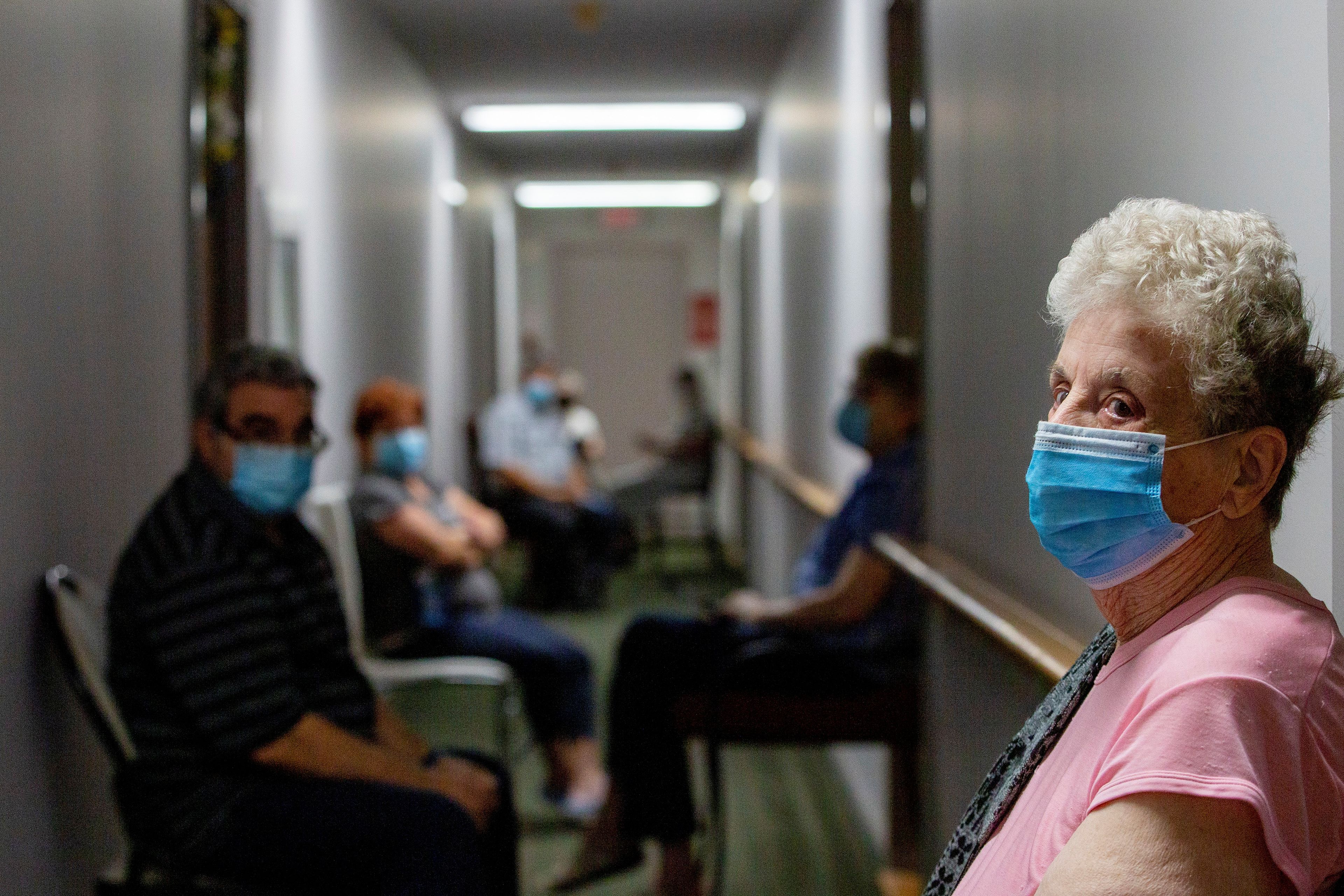 Personas mayores esperan en un hospital para recibir la vacuna COVID-19