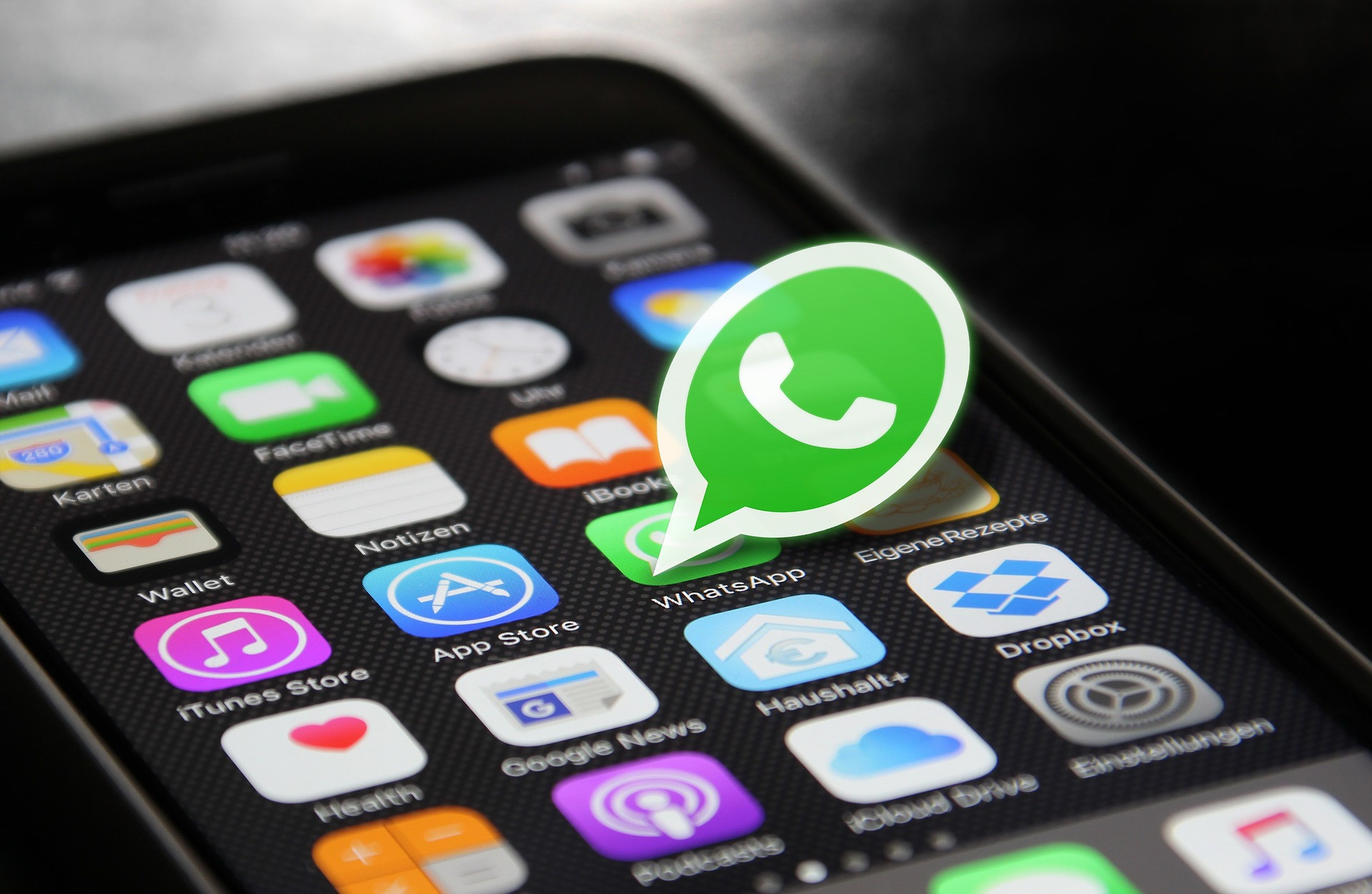 Un símbolo de WhatsApp señala al símbolo de WhatsApp en un teléfono móvil.