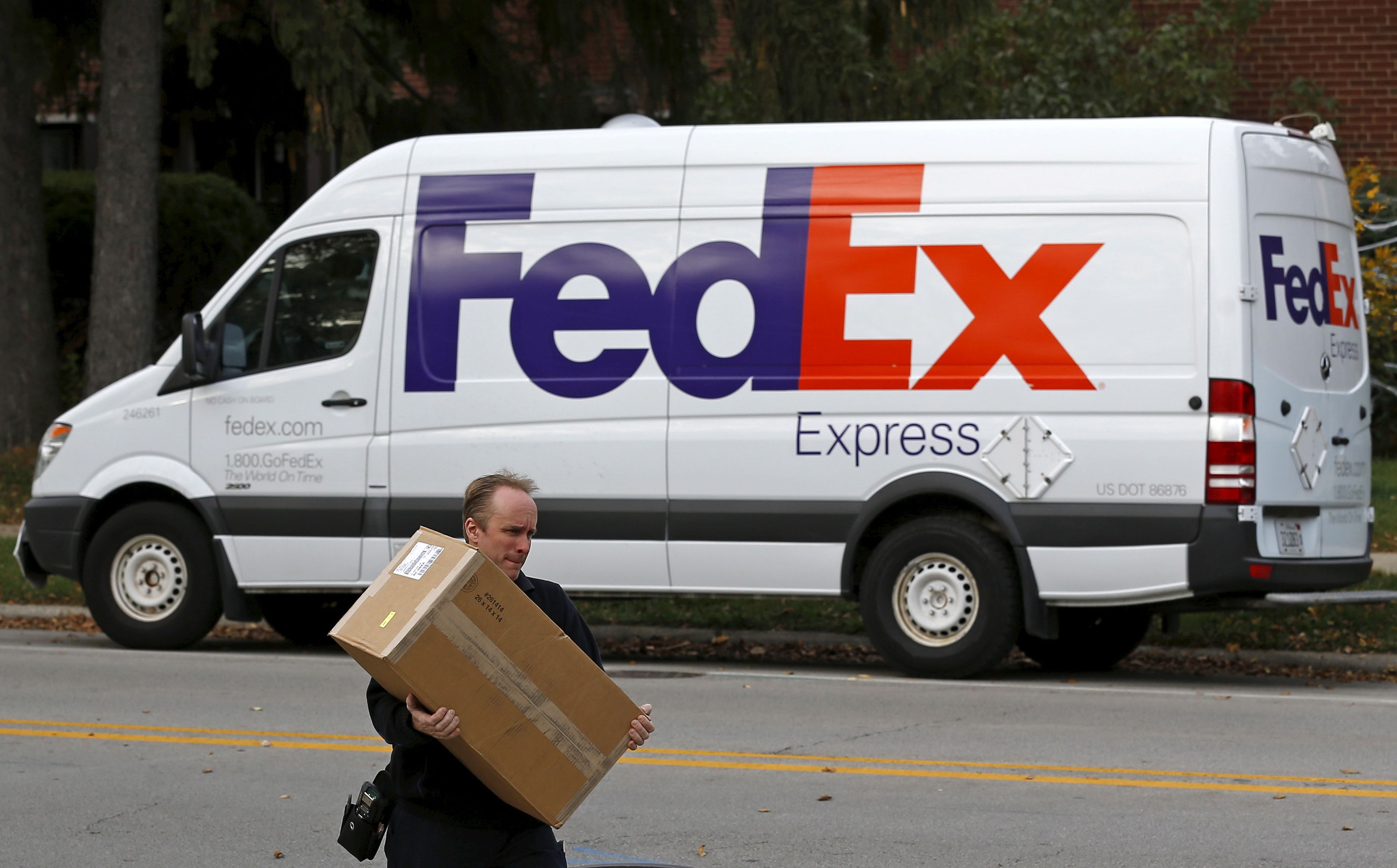 Trabajador de Fedex llevando un paquete