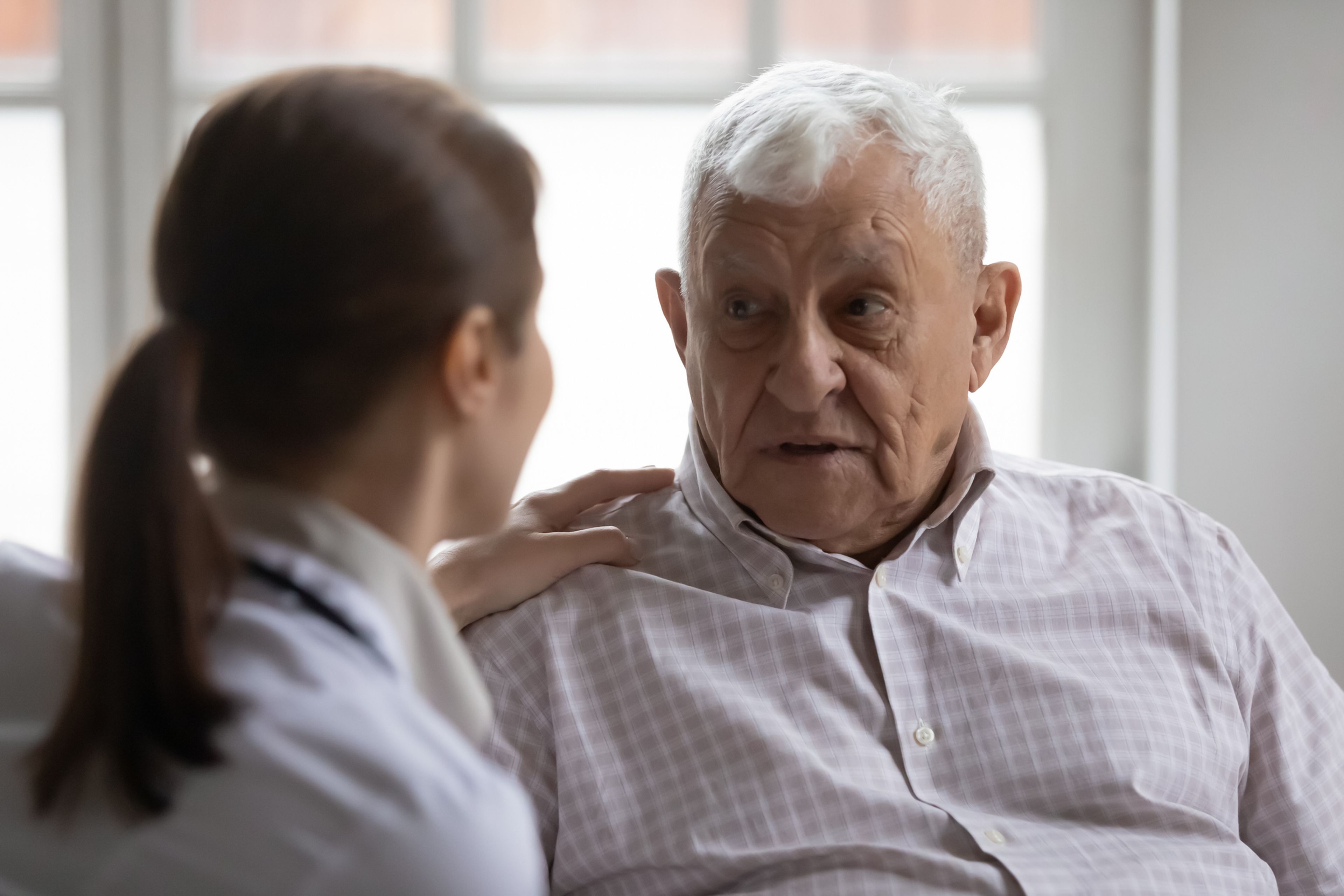 Conversación de hombre mayor con enfermera joven