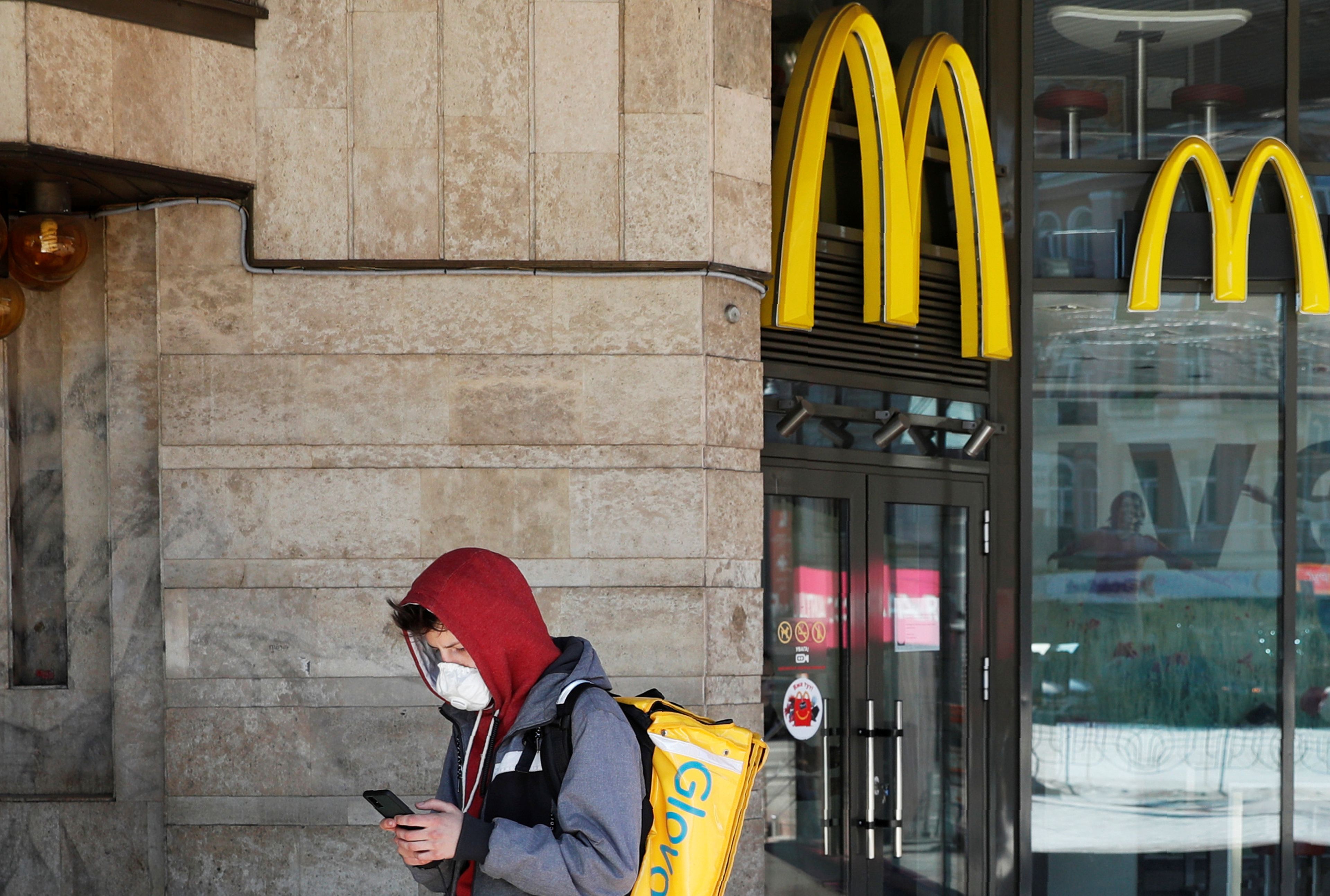 Un repartidor de Glovo frente a la puerta de un establecimiento de McDonald's, una pieza clave en la expansión de la catalana.