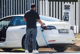 Un hombre carga un coche eléctrico