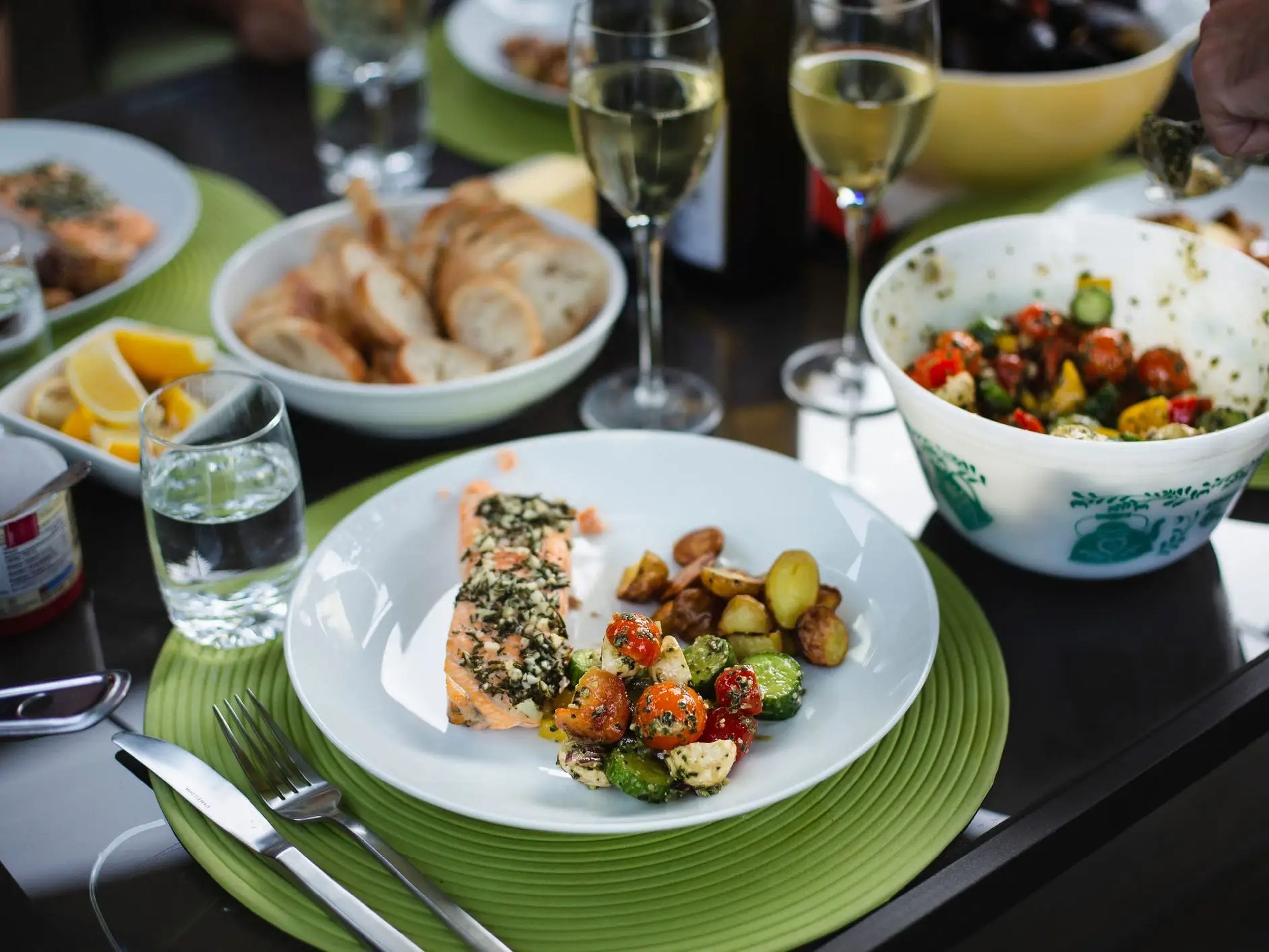 Mediterranean diet meal with salmon, wine, and vegetables