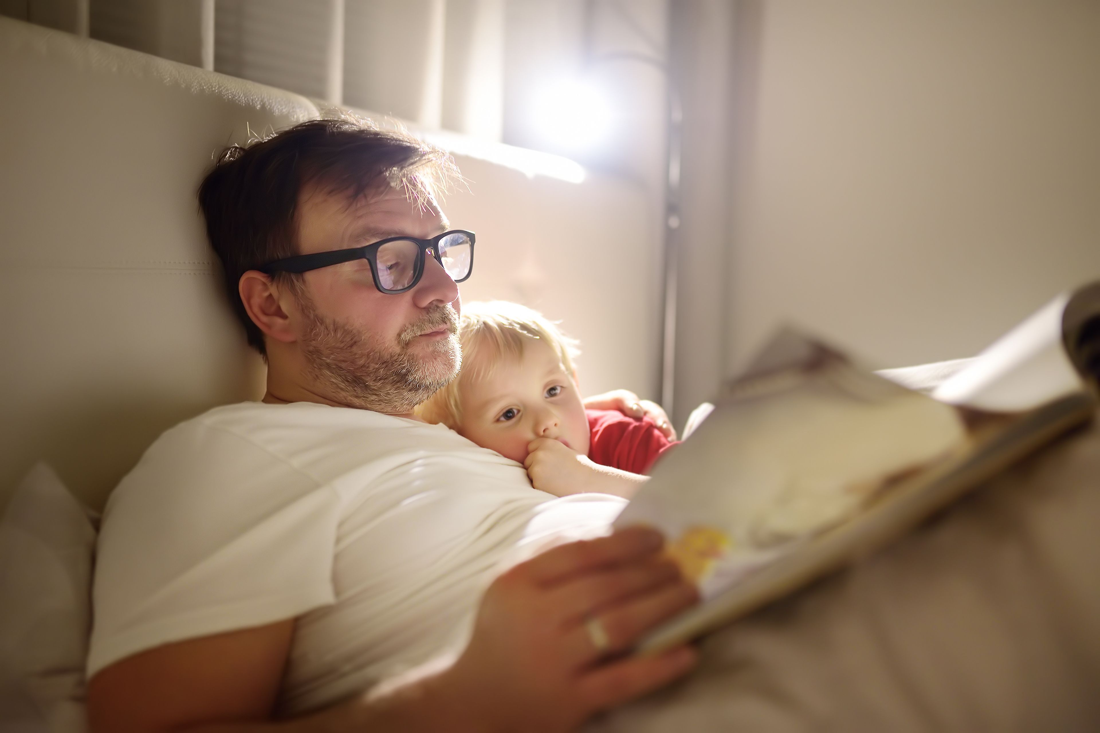 Un padre le lee un cuento a su hijo.