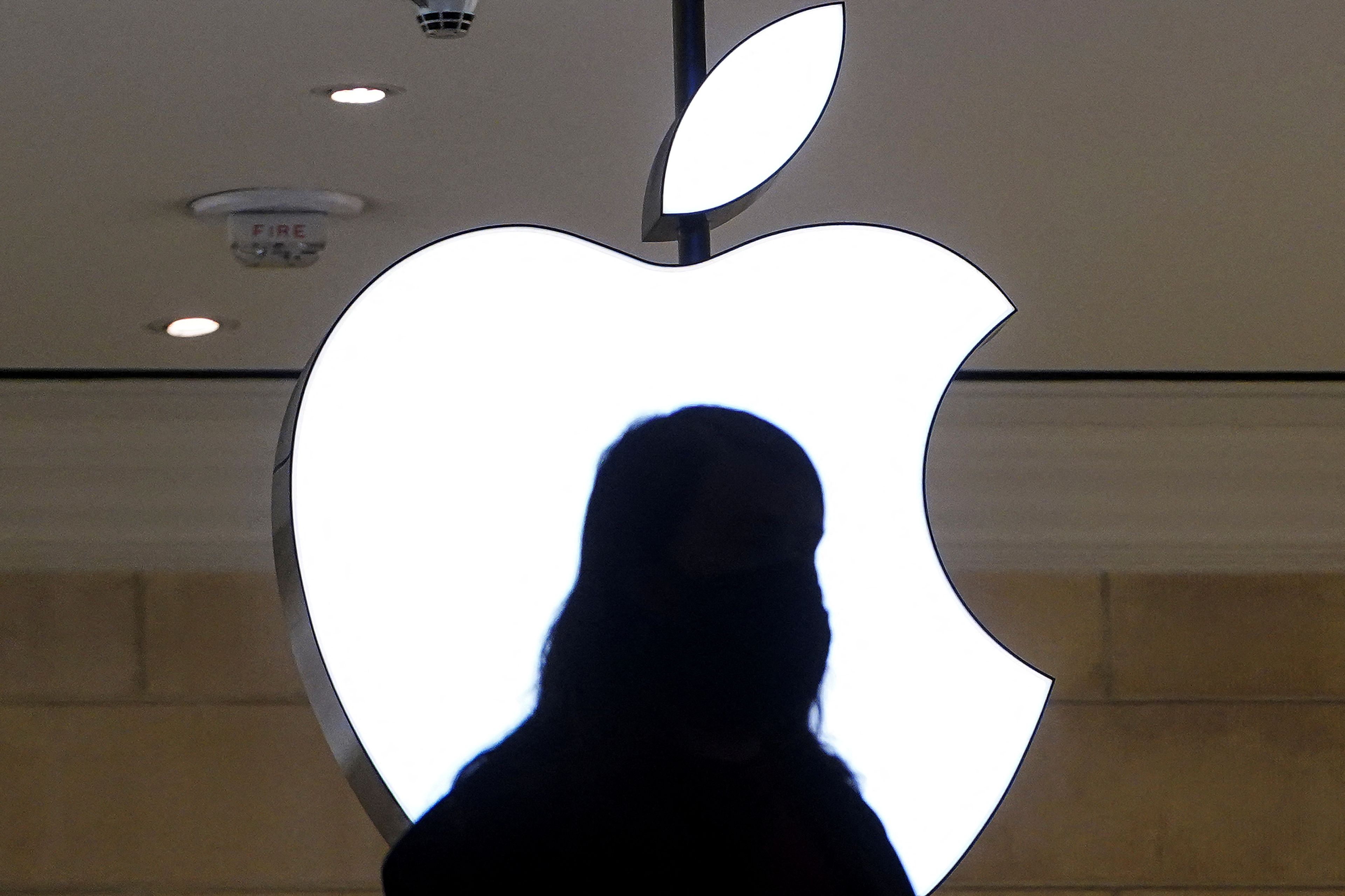 Una persona delante de un logo de Apple