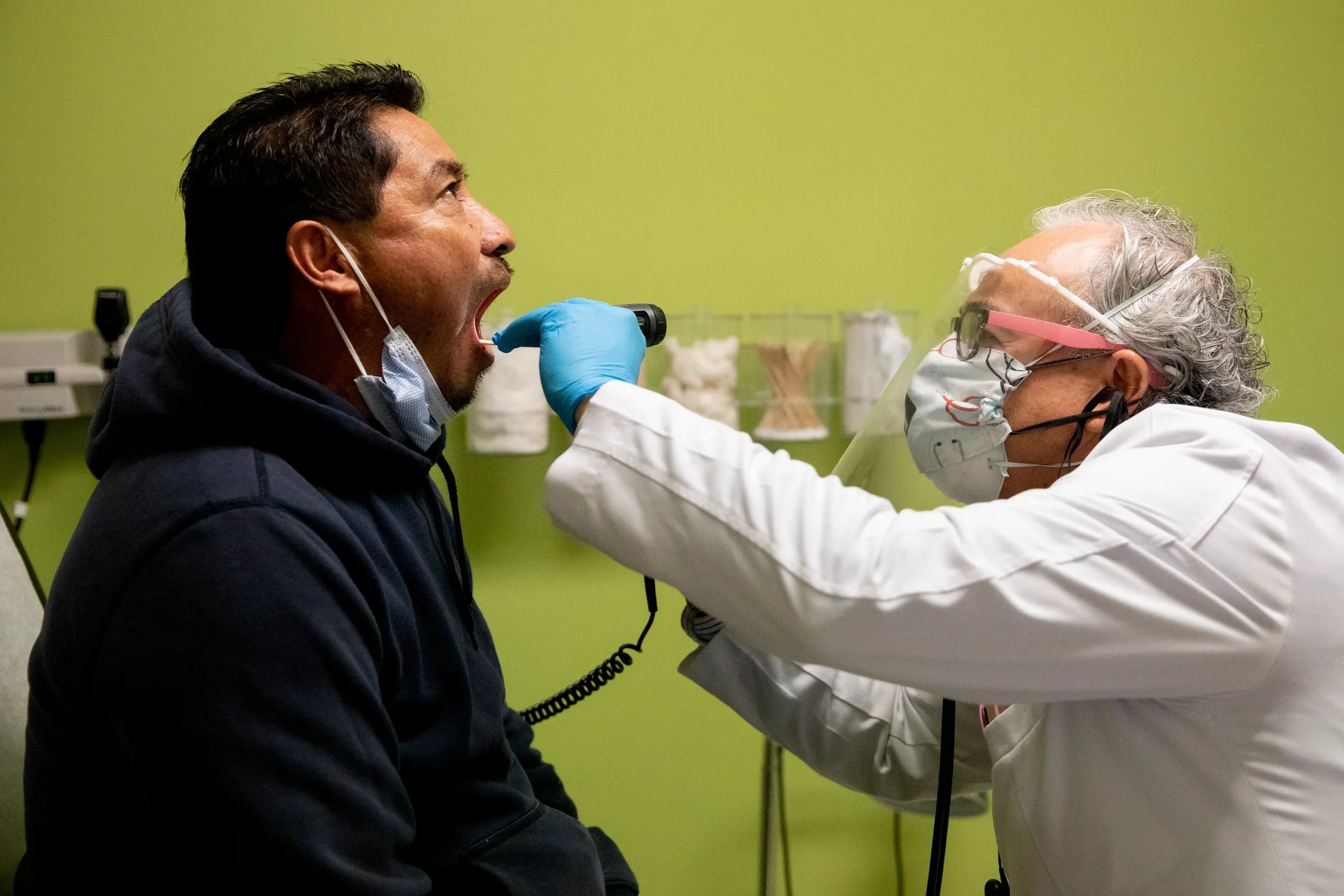 El doctor Carlos Ramírez realiza una evaluación a Juan Pérez, de 50 años, en Oakland, California, Estados Unidos, el 12 de mayo de 2020.