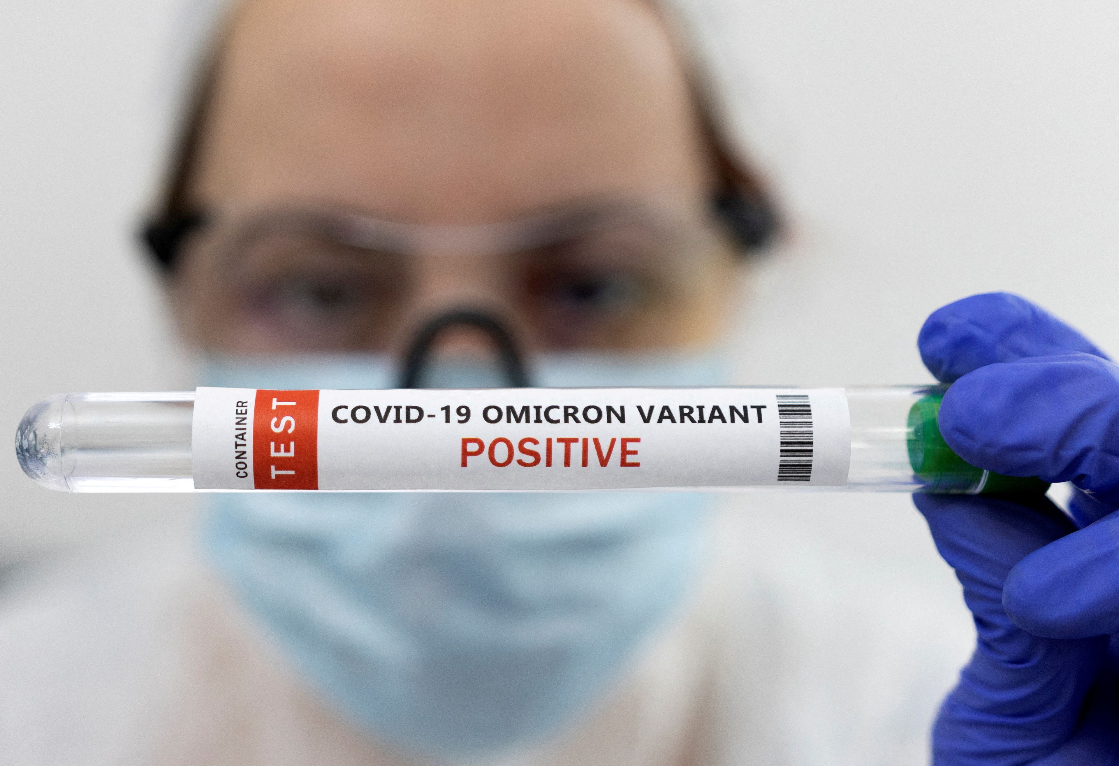 Un tubo de ensayo con la etiqueta de prueba positiva de la variante ómicron de COVID-19