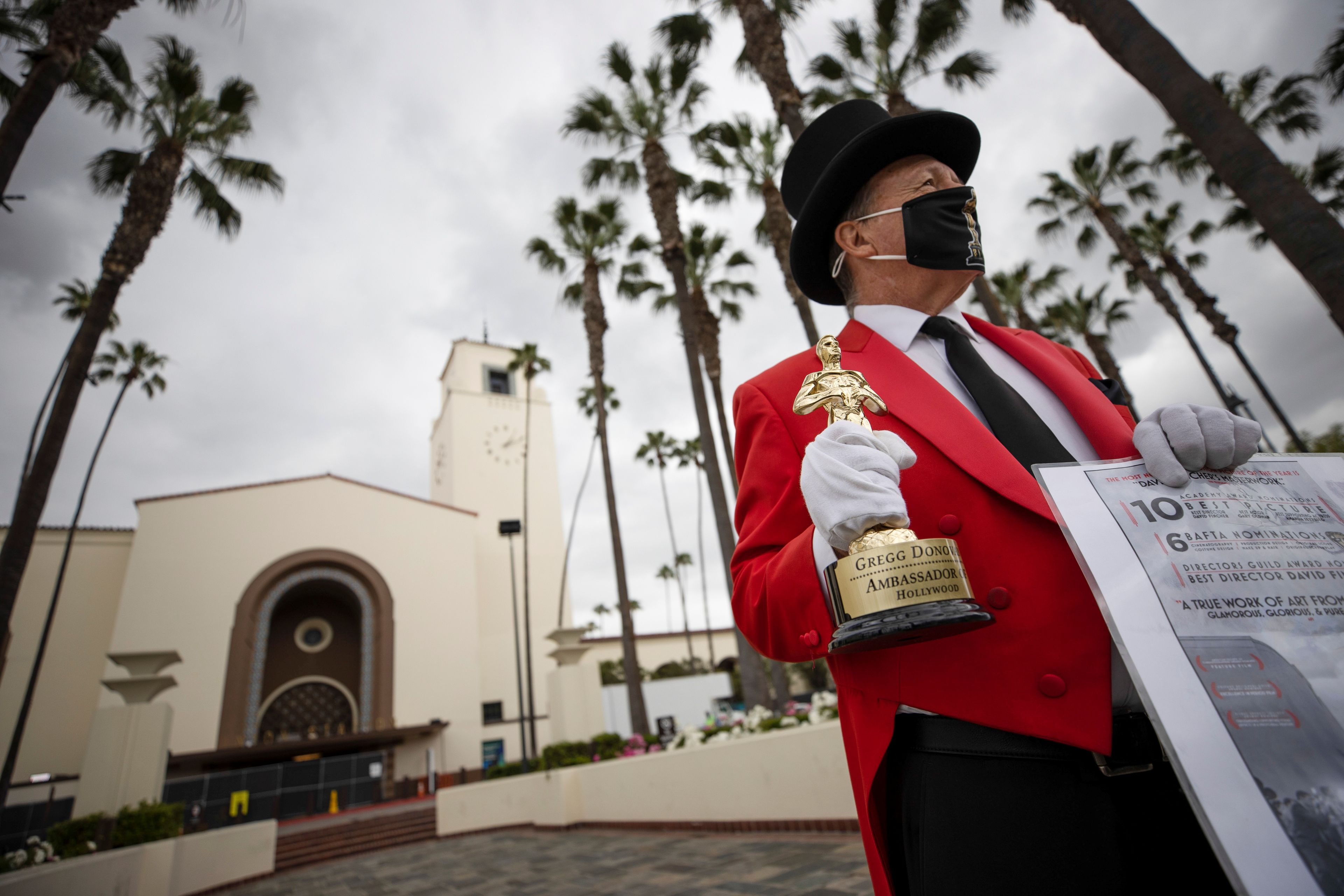 El autoproclamado embajador de Hollywood, Gregg Donovan, sostiene una réplica de la estatuilla de los Oscar frente a Union Station durante los preparativos para la 93.ª edición de los Premios de la Academia en Los Ángeles.