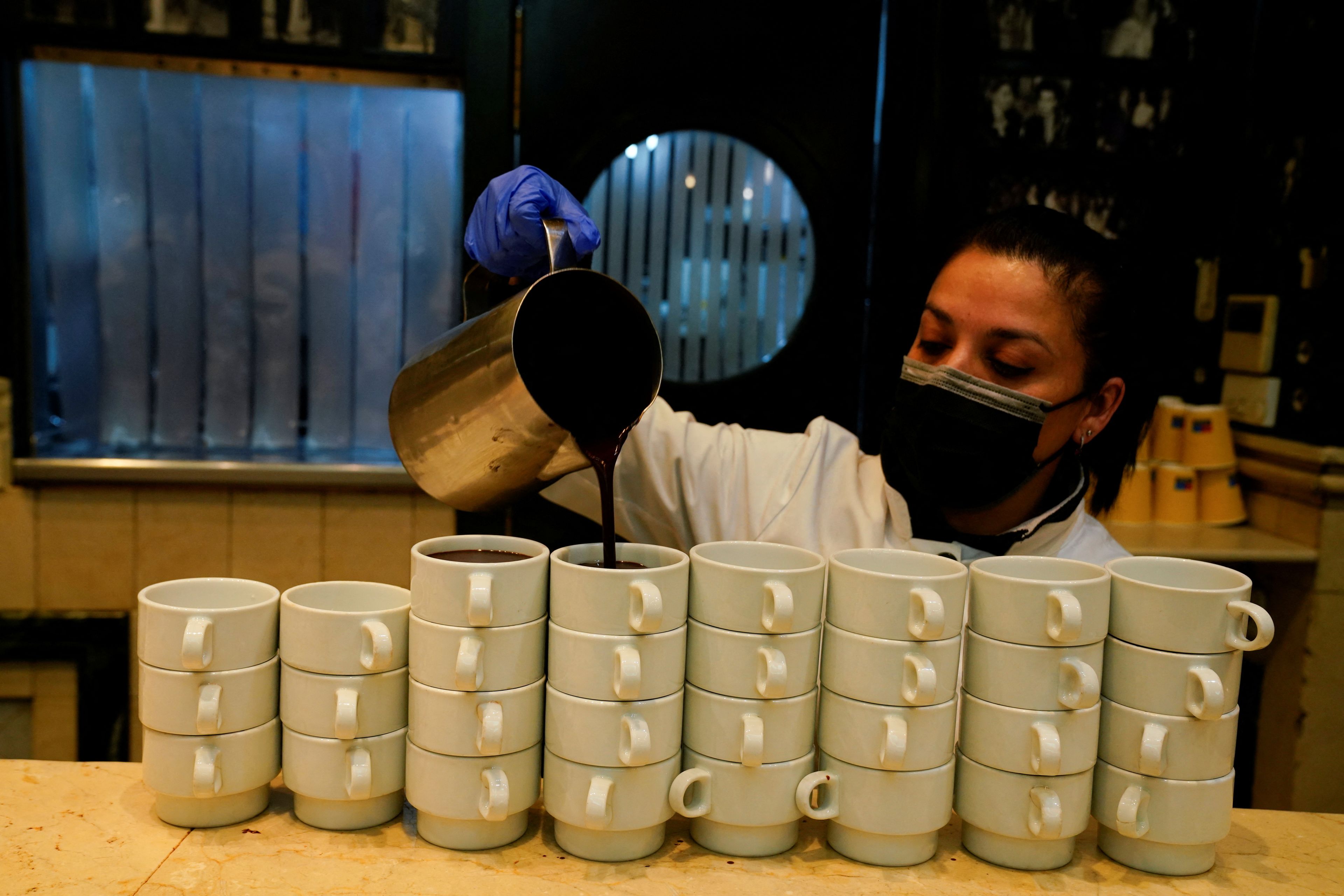 Una camarera sirve chocolate caliente en una cafetería de Madrid