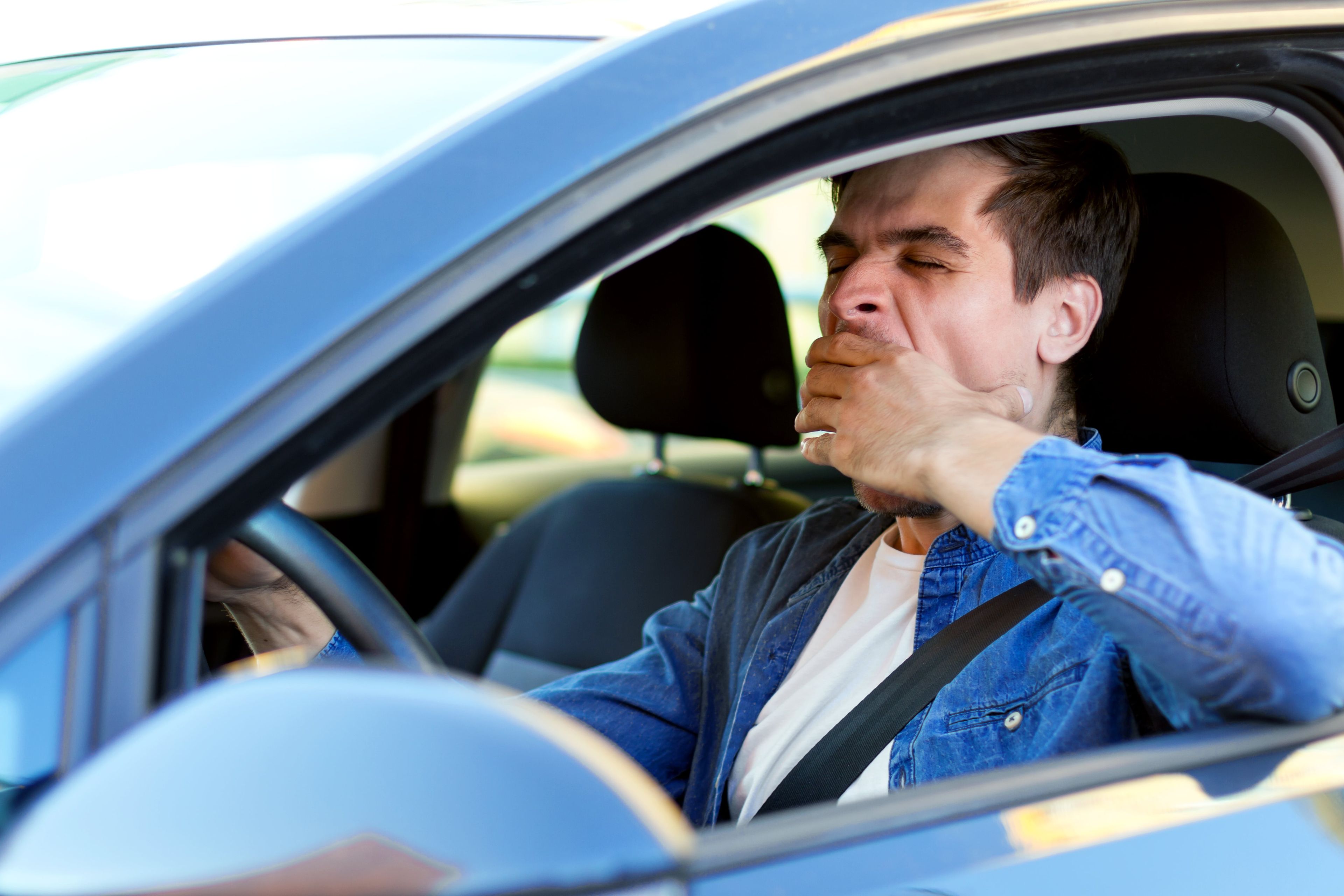 Un hombre bosteza al conducir