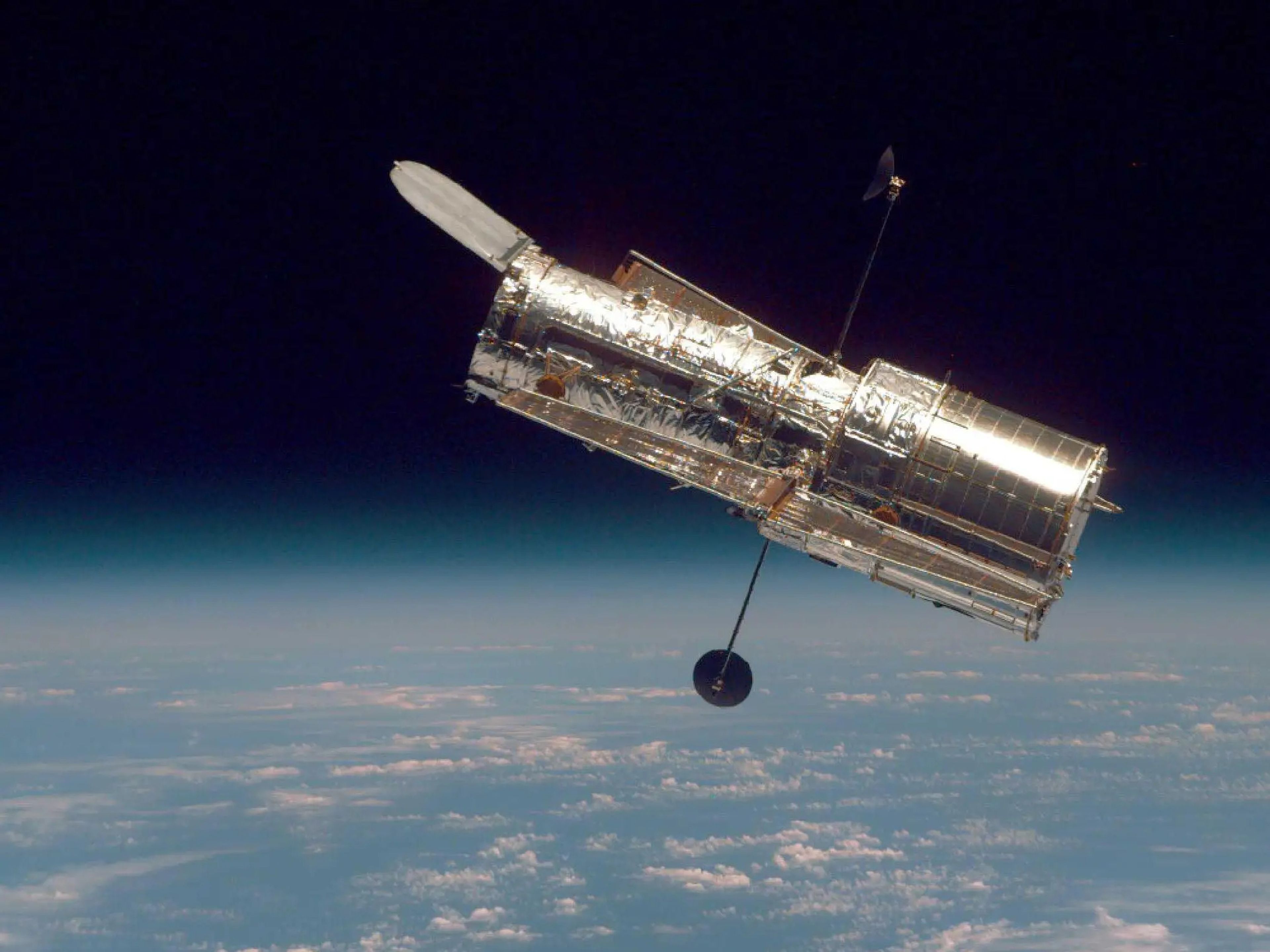 El telescopio espacial Hubble flota en el límite entre la Tierra y el espacio en esta imagen, tomada después de la segunda misión de servicio del Hubble en 1997.