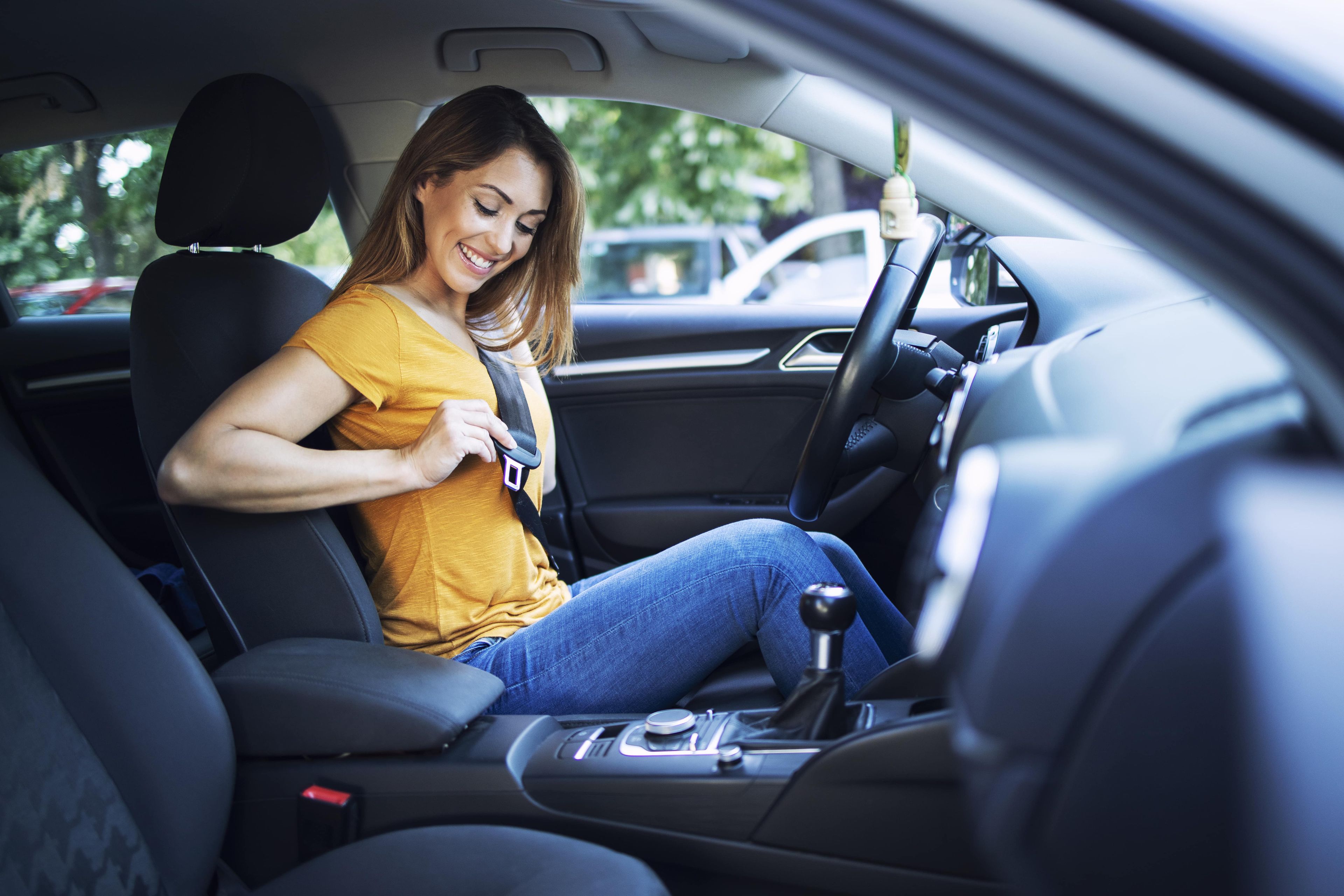 Una mujer se pone el cinturón de seguridad en el coche