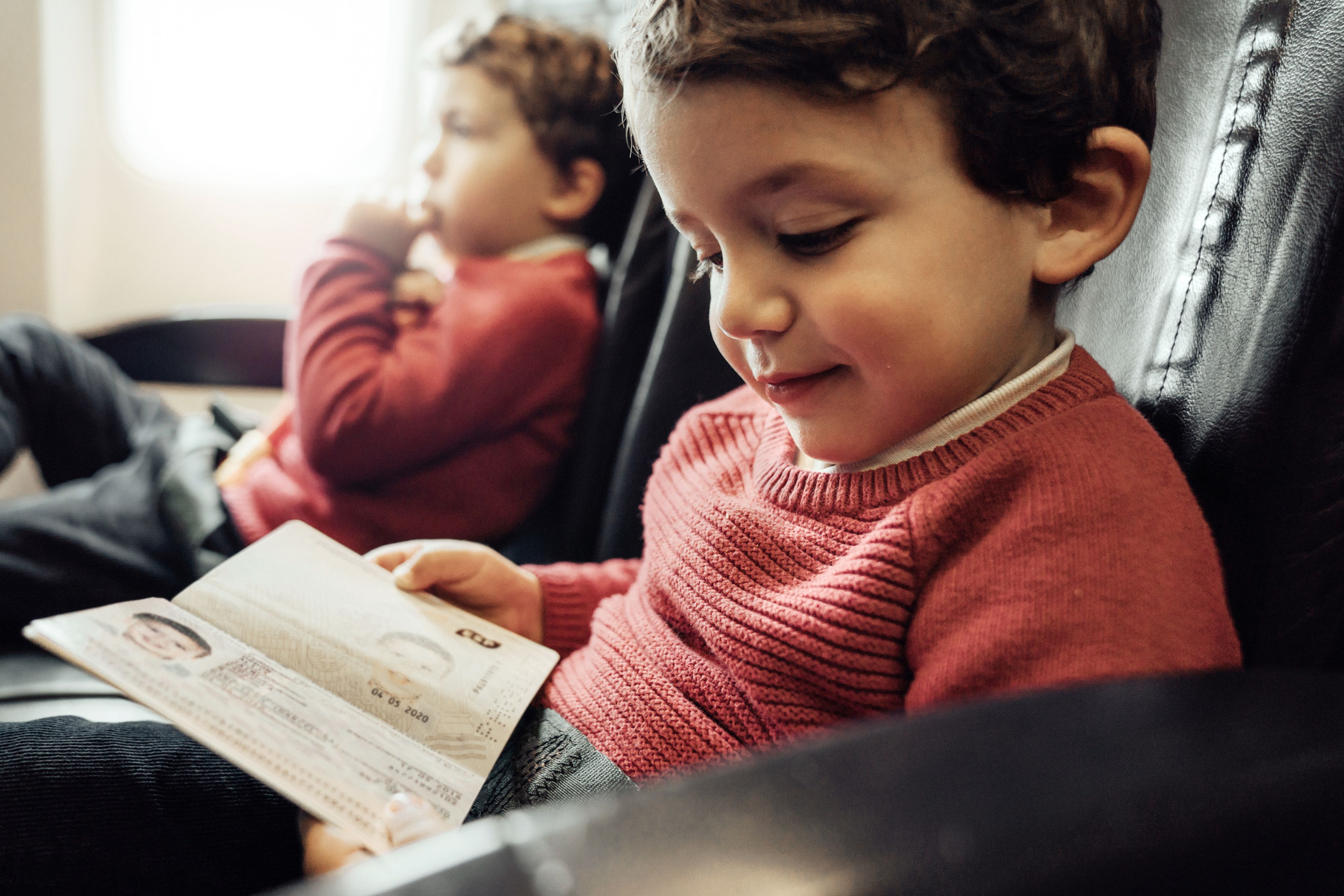 Niño con pasaporte, en un avión