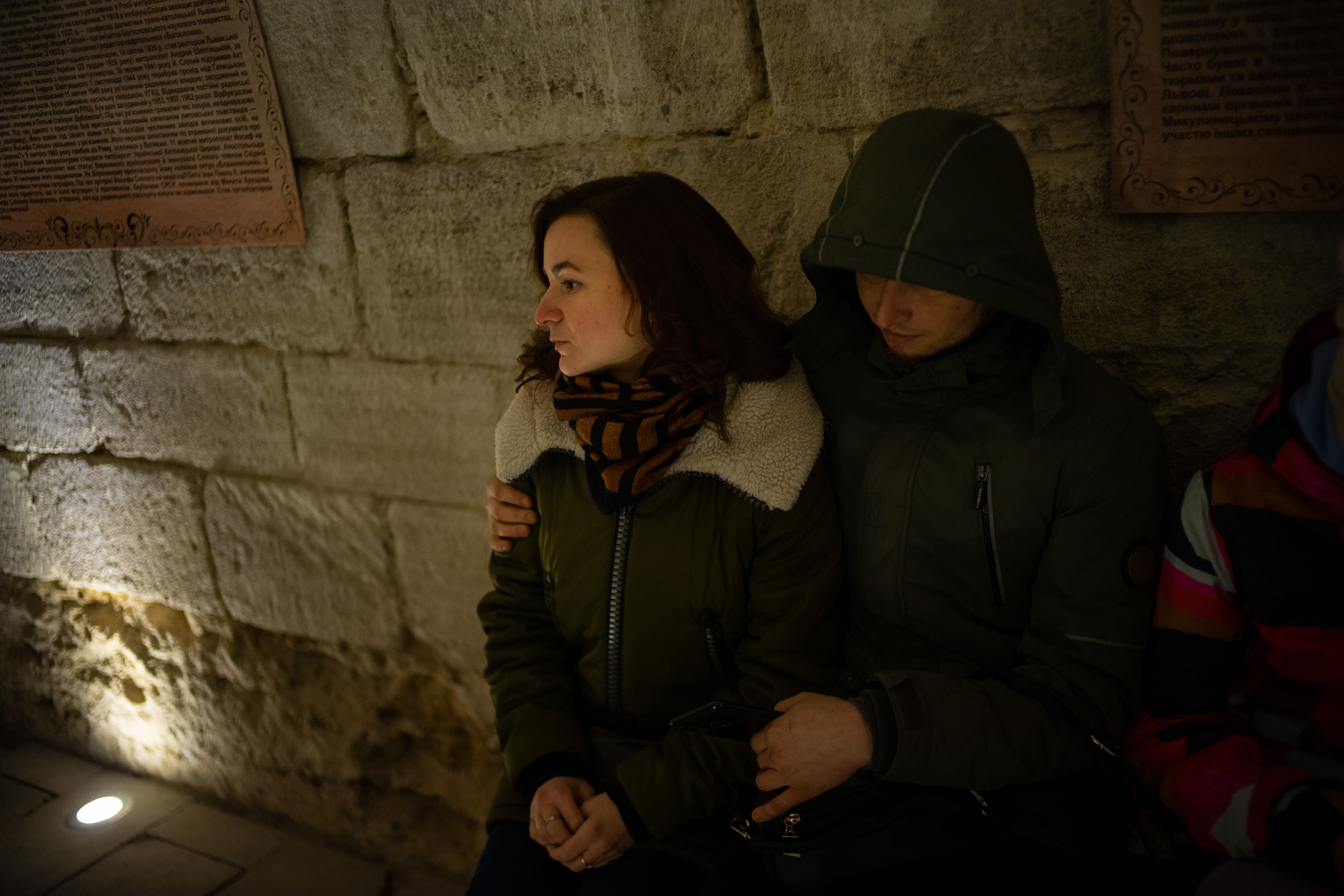 Una pareja preocupada sentada en el interior del refugio antiaéreo de la iglesia.