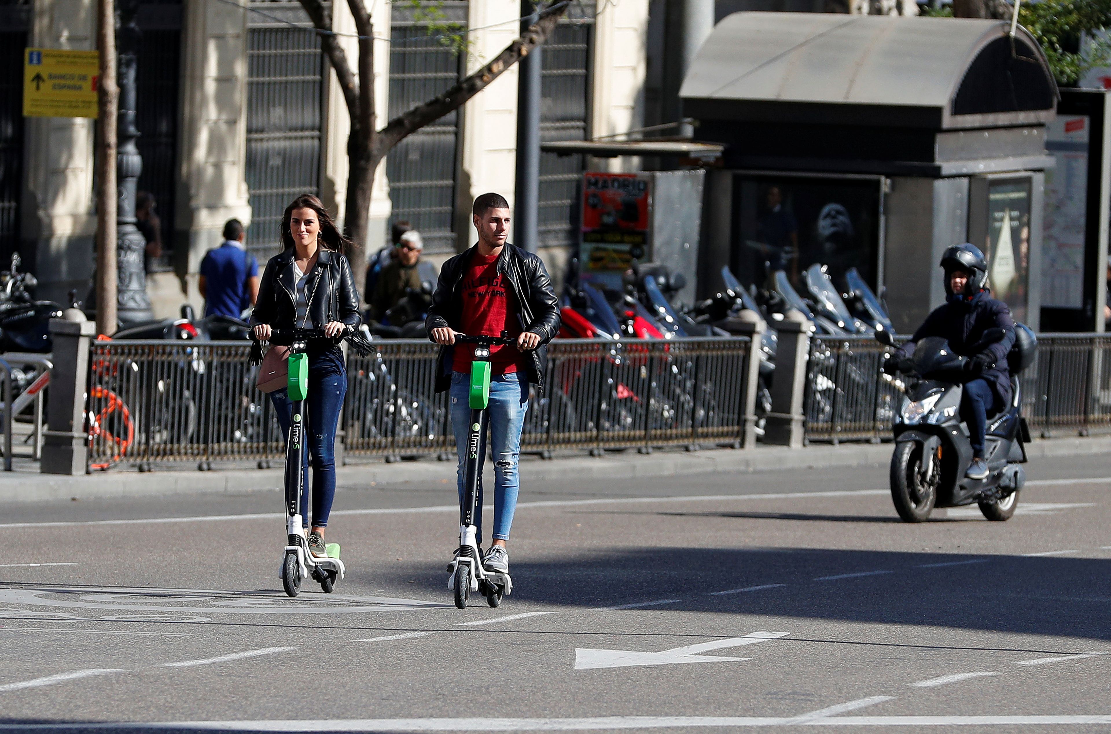 Una pareja utilizando patinetes eléctrico en Madrid