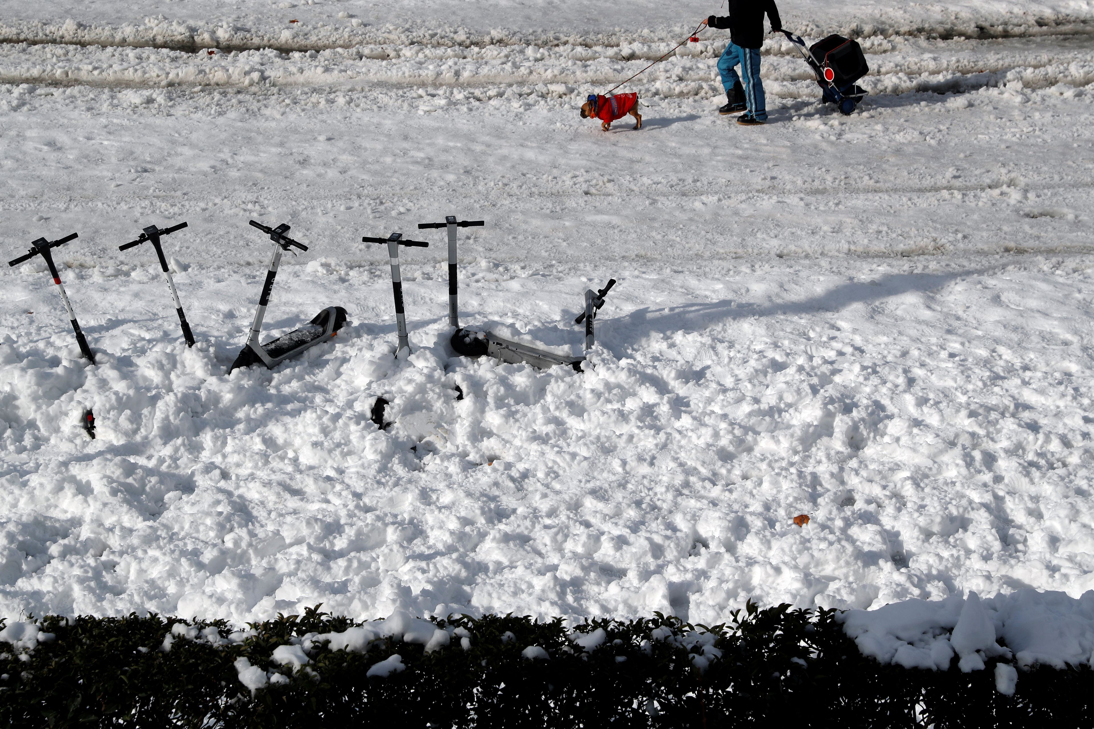 Patinetes enterrados en la nieve en Madrid durante la borrasca Filomena en enero de 2021.