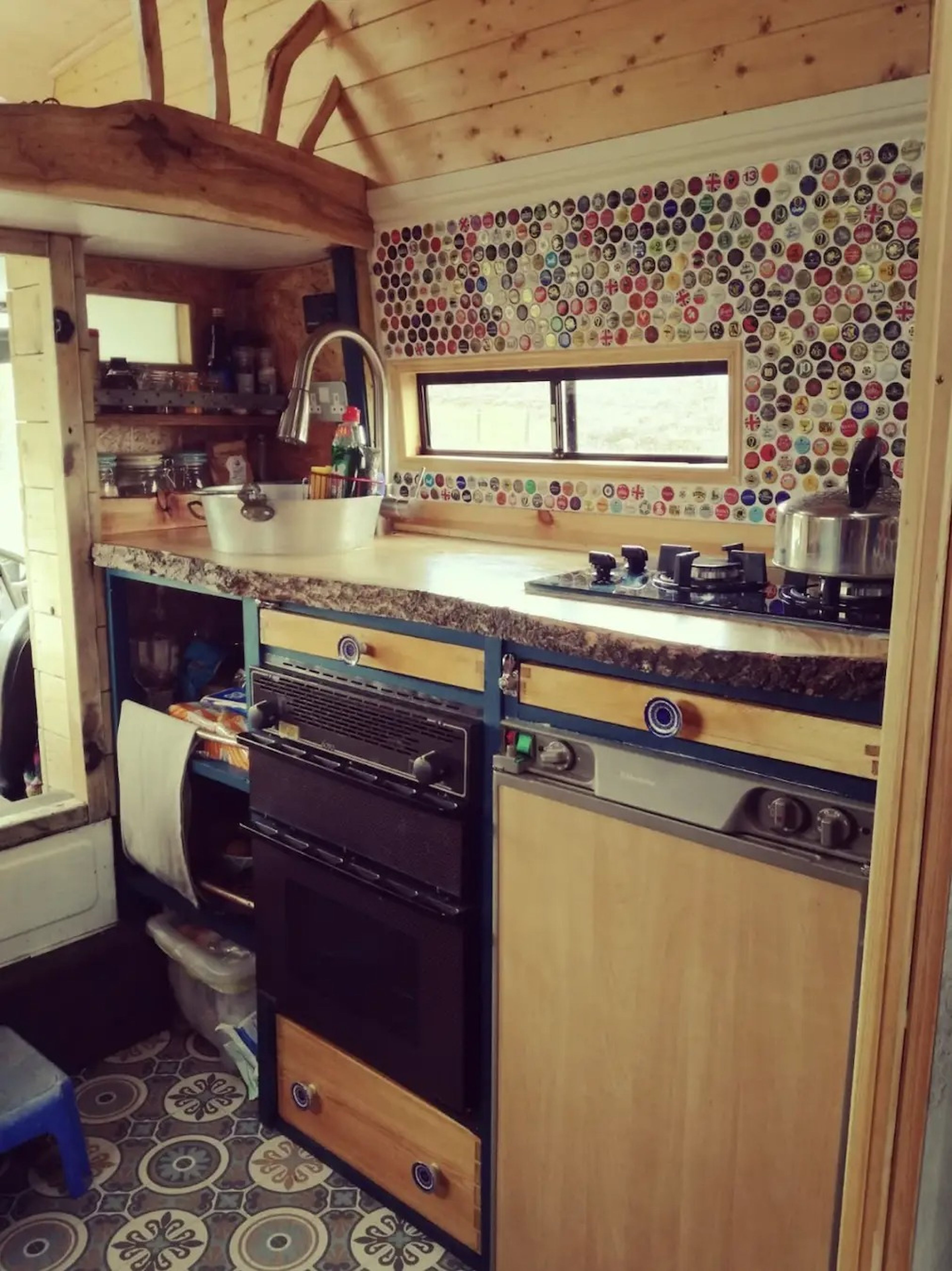 La cocina está decorada con azulejos y cuenta con horno a gas y fogones.