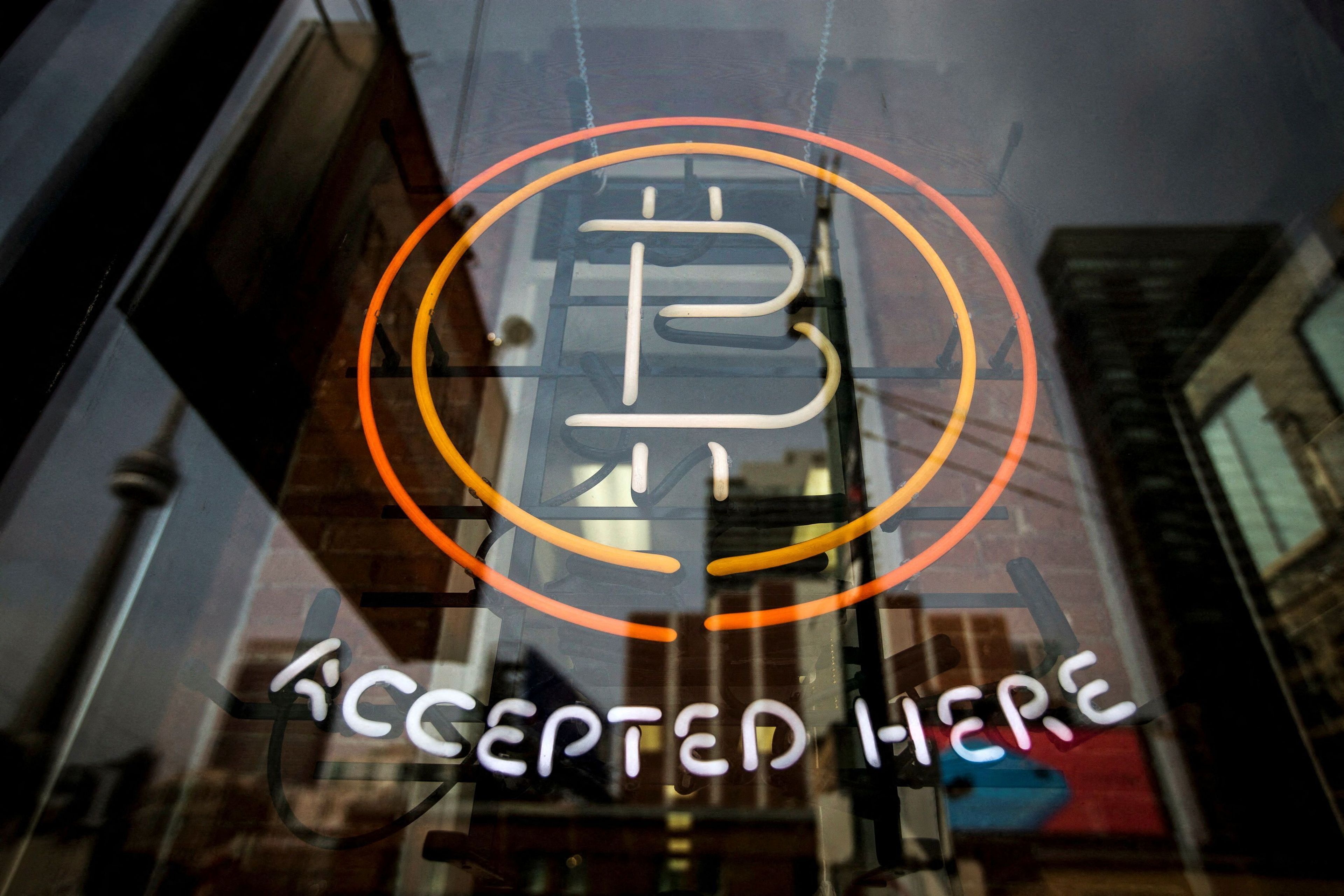 Un anuncio luminoso en una tienda, indicando que aceptan bitcoin.