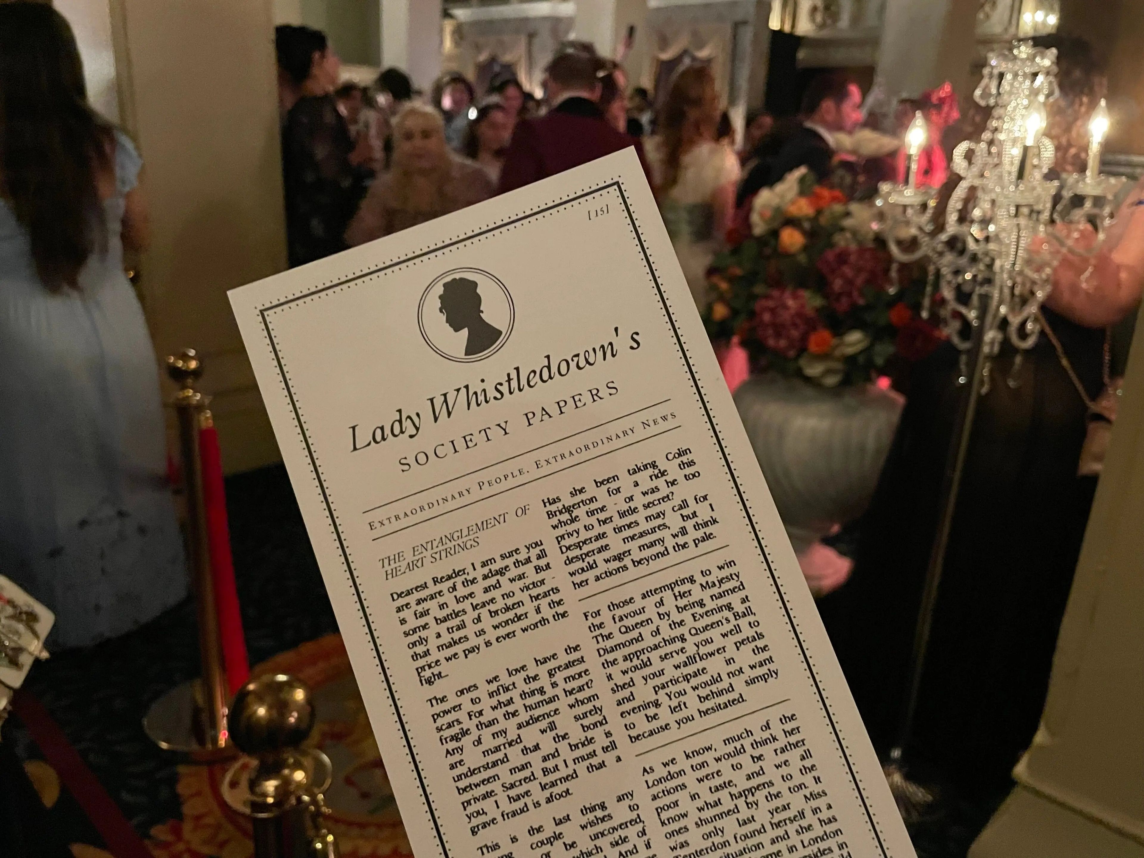 Los asistentes al baile reciben una edición del panfleto de chismes que escribe Lady Whistledown en 'Bridgerton'.