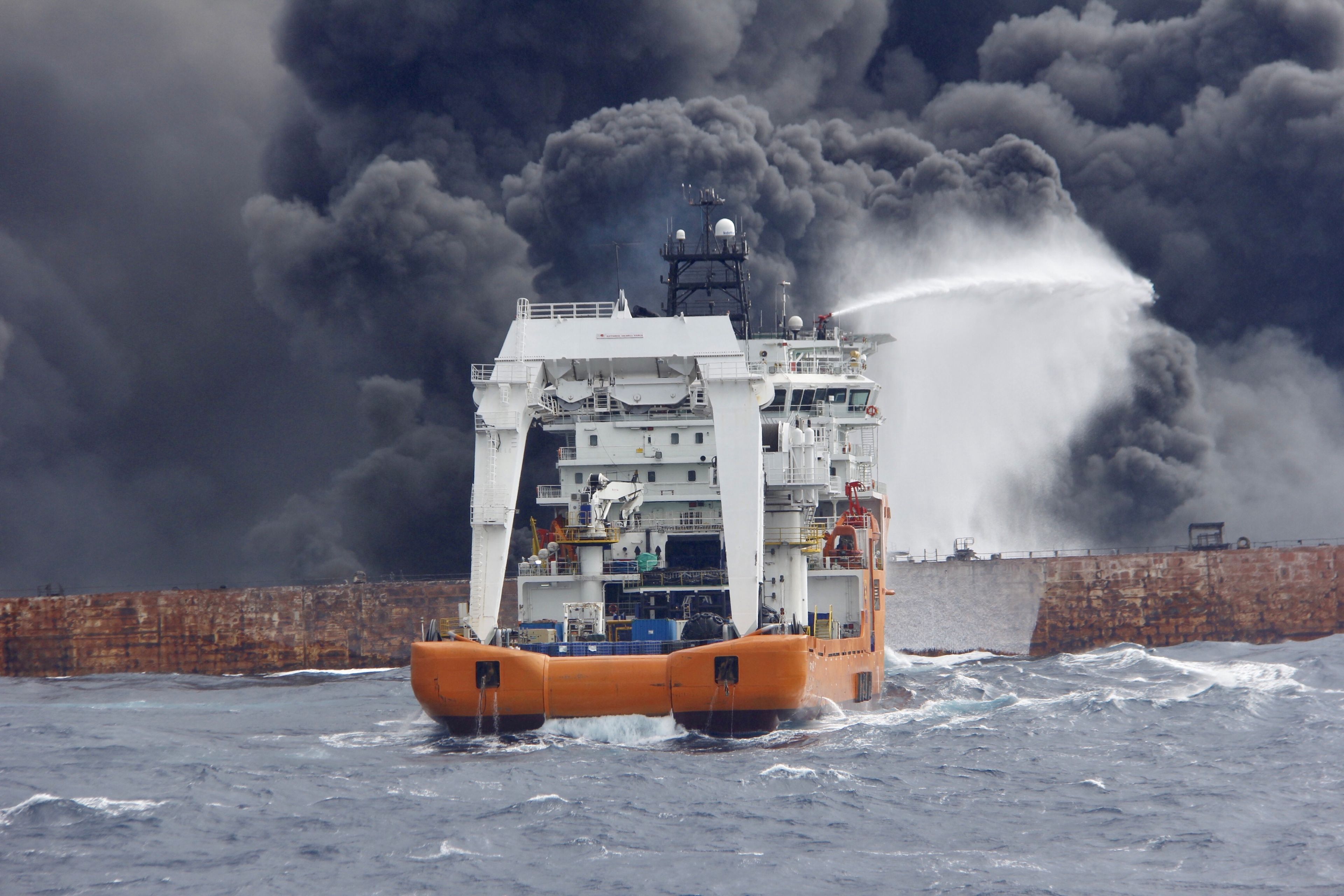 Un barco de rescate extingue un incendio en un petrolero en el Mar de China Oriental.