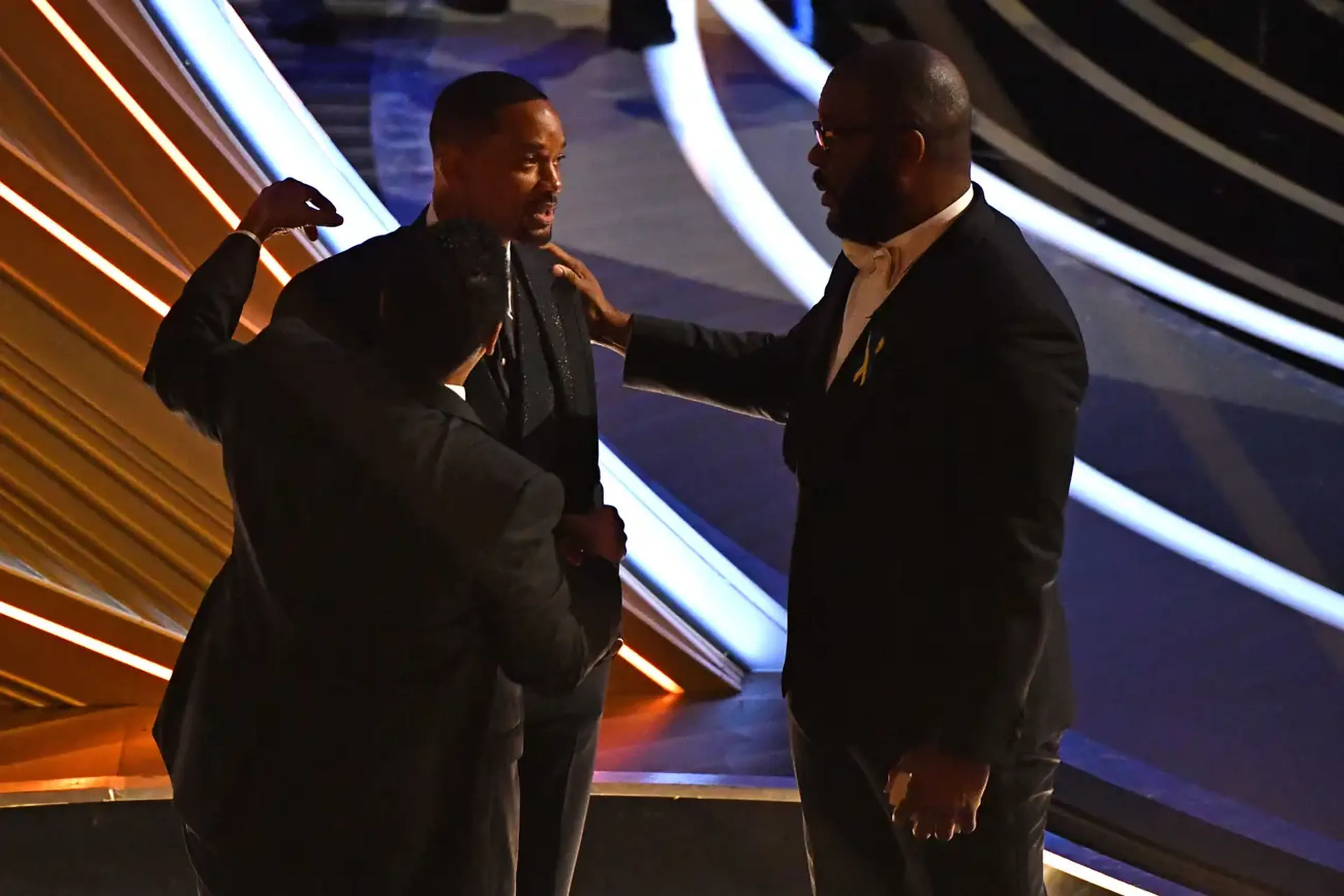 Denzel Washington y Tyler Perry hablando con Will Sith después de que Smith golpeara a Chris Rock en el escenario de los Oscar.