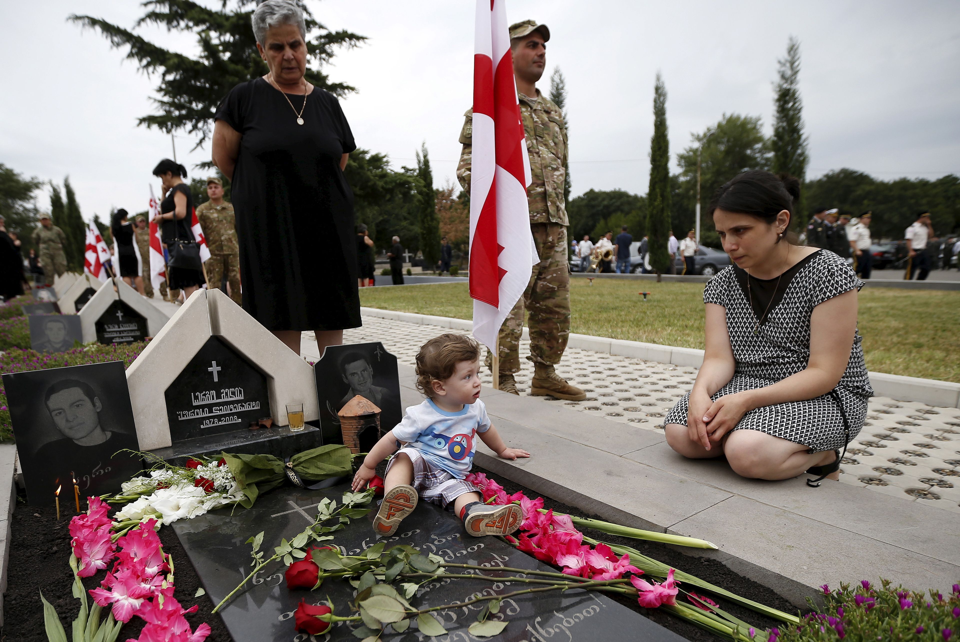 Familiares de soldados georgianos muertos durante la guerra con Rusia lamentan su pérdida en una ceremonia.