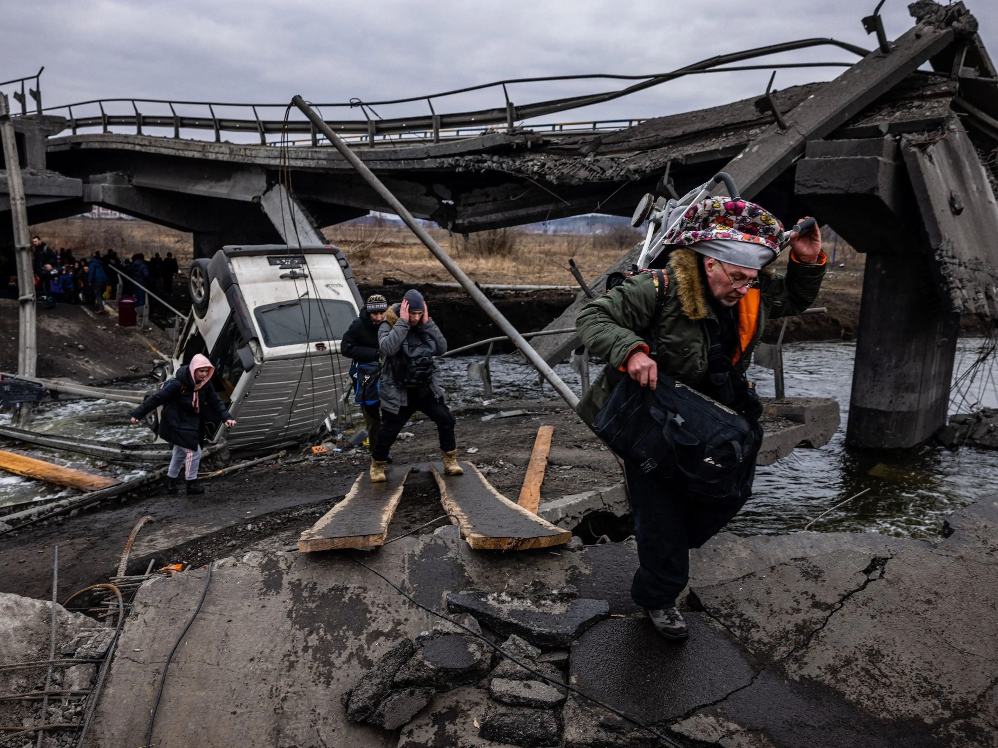 Los evacuados cruzan un puente destruido mientras huyen de la ciudad de Irpín, al noroeste de Kiev, el 7 de marzo de 2022.