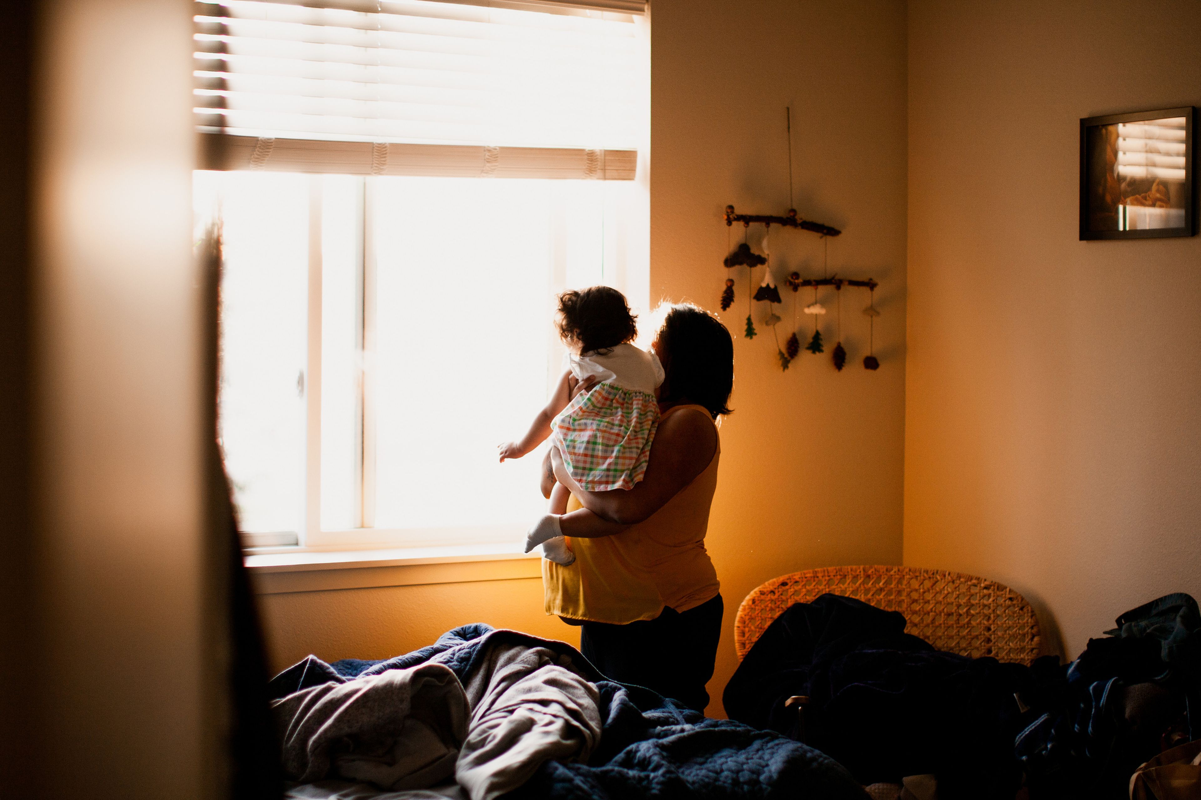 Una madre y su hija miran por la ventana.