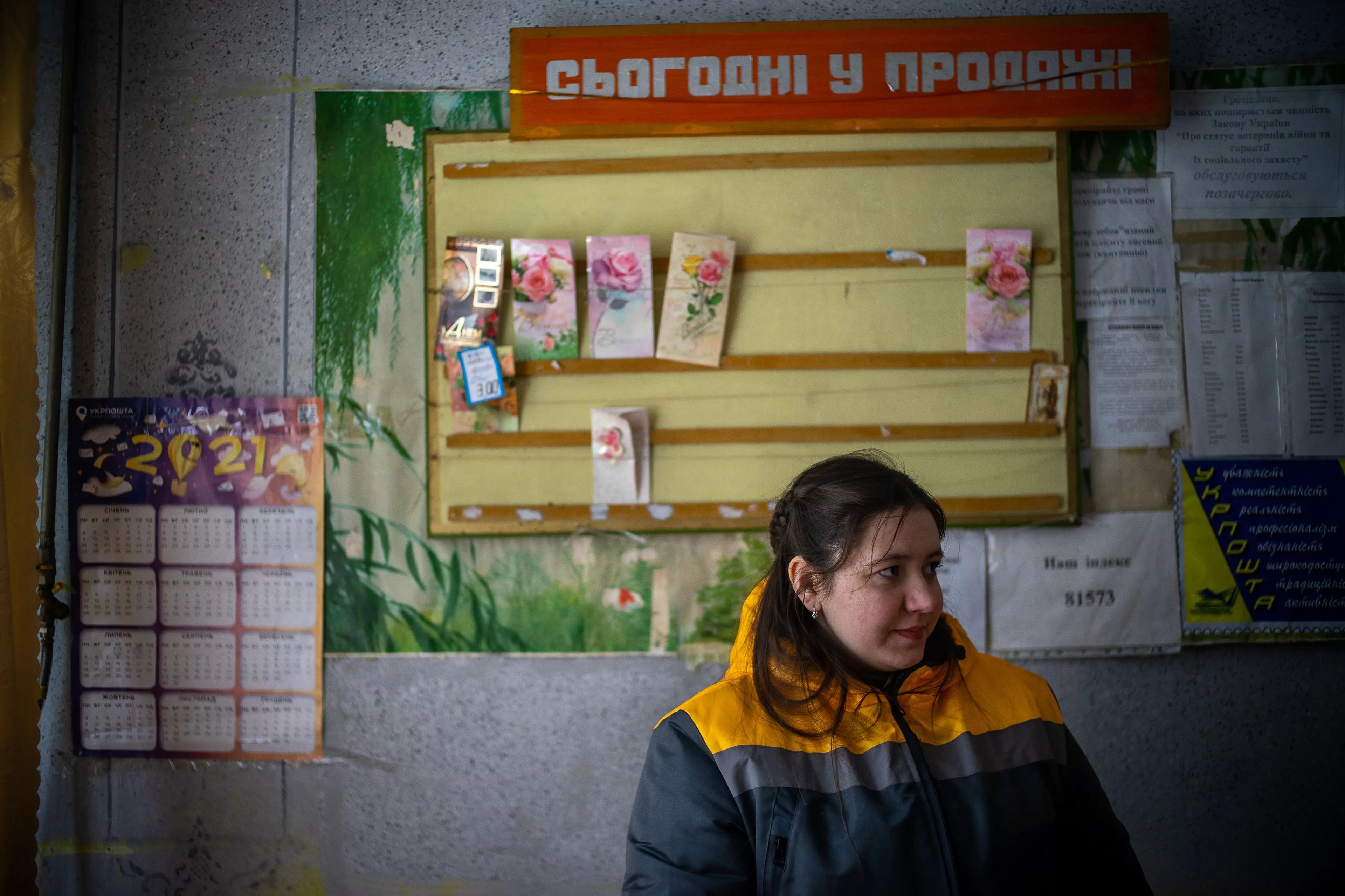 Maria Lukashevych se sienta delante de un expositor de tarjetas de felicitación en la oficina de correos del pueblo de Nove Selo.