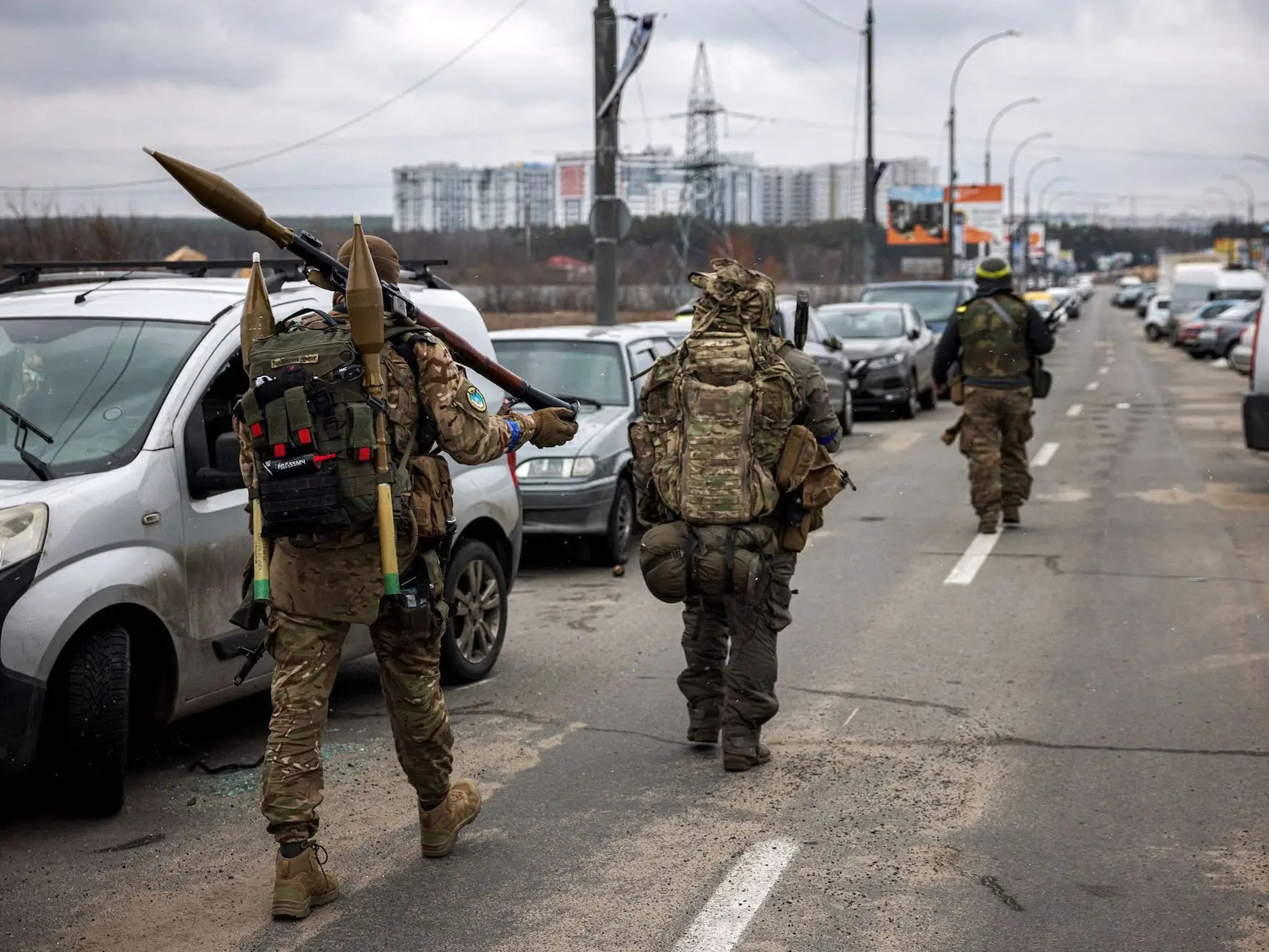 Militares ucranianos llevan granadas propulsadas por cohetes y rifles de francotirador hacia la ciudad de Irpin, al noroeste de Kiev, el 13 de marzo de 2022.