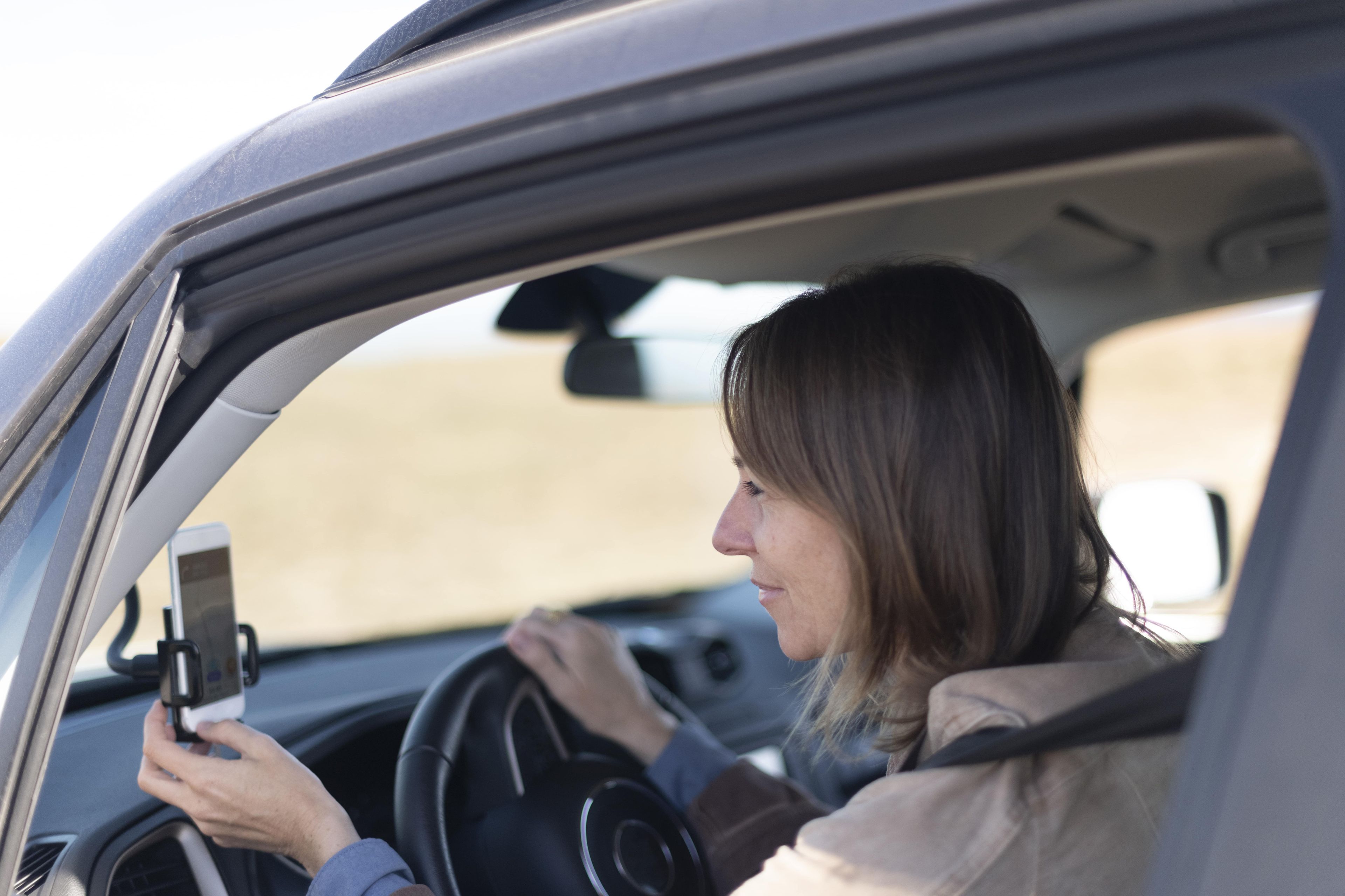 Una mujer consulta el móvil mientras conduce