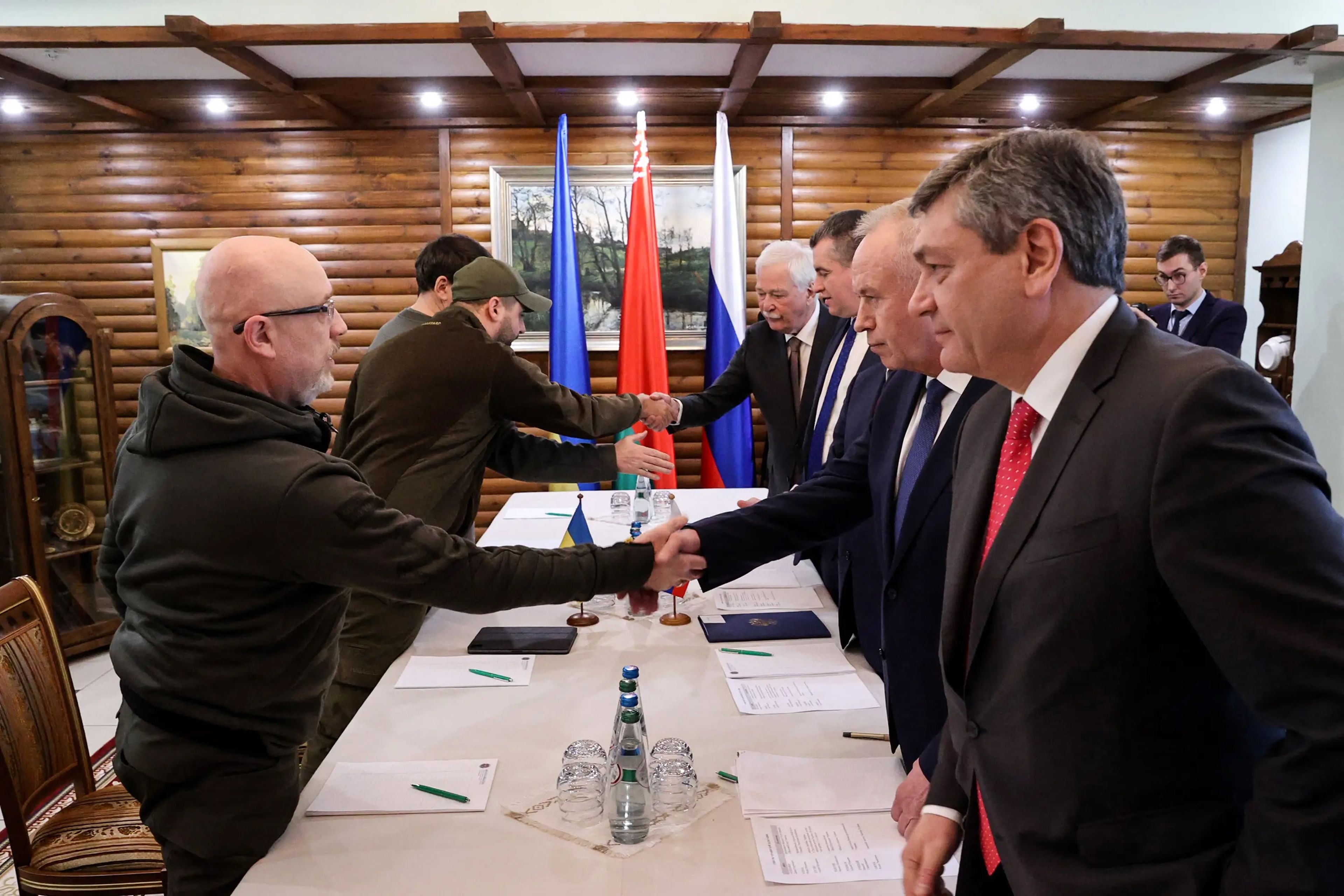 El ministro de Defensa ucraniano, Oleksii Reznikov (izquierda), estrecha la mano de los negociadores rusos antes de las conversaciones mantenidas en Bielorrusia el 3 de marzo de 2022.