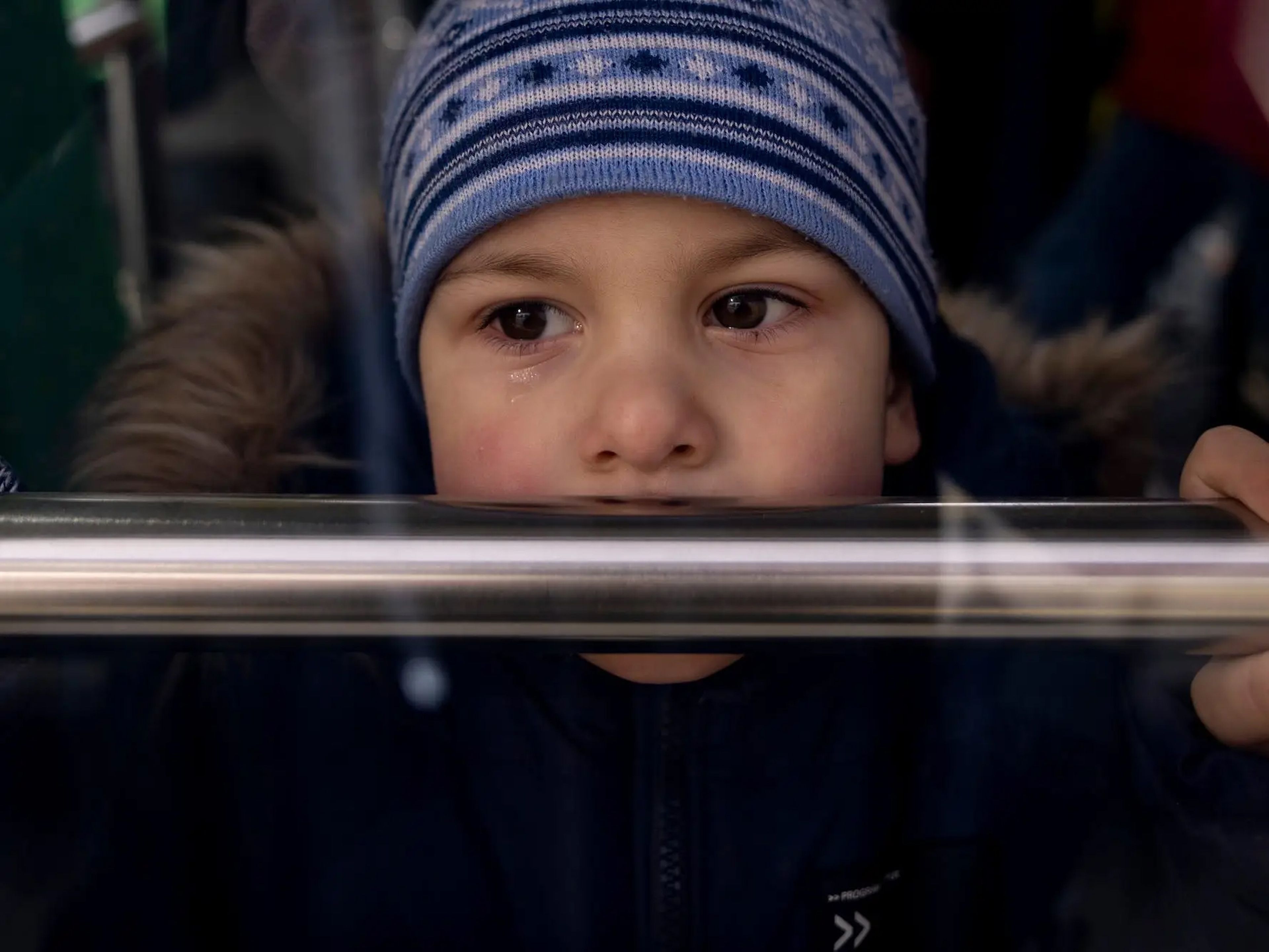Un niño llora mientras las familias suben a los autobuses hacia la frontera con Polonia el 12 de marzo de 2022 en la ciudad de Leópolis, en el oeste de Ucrania.