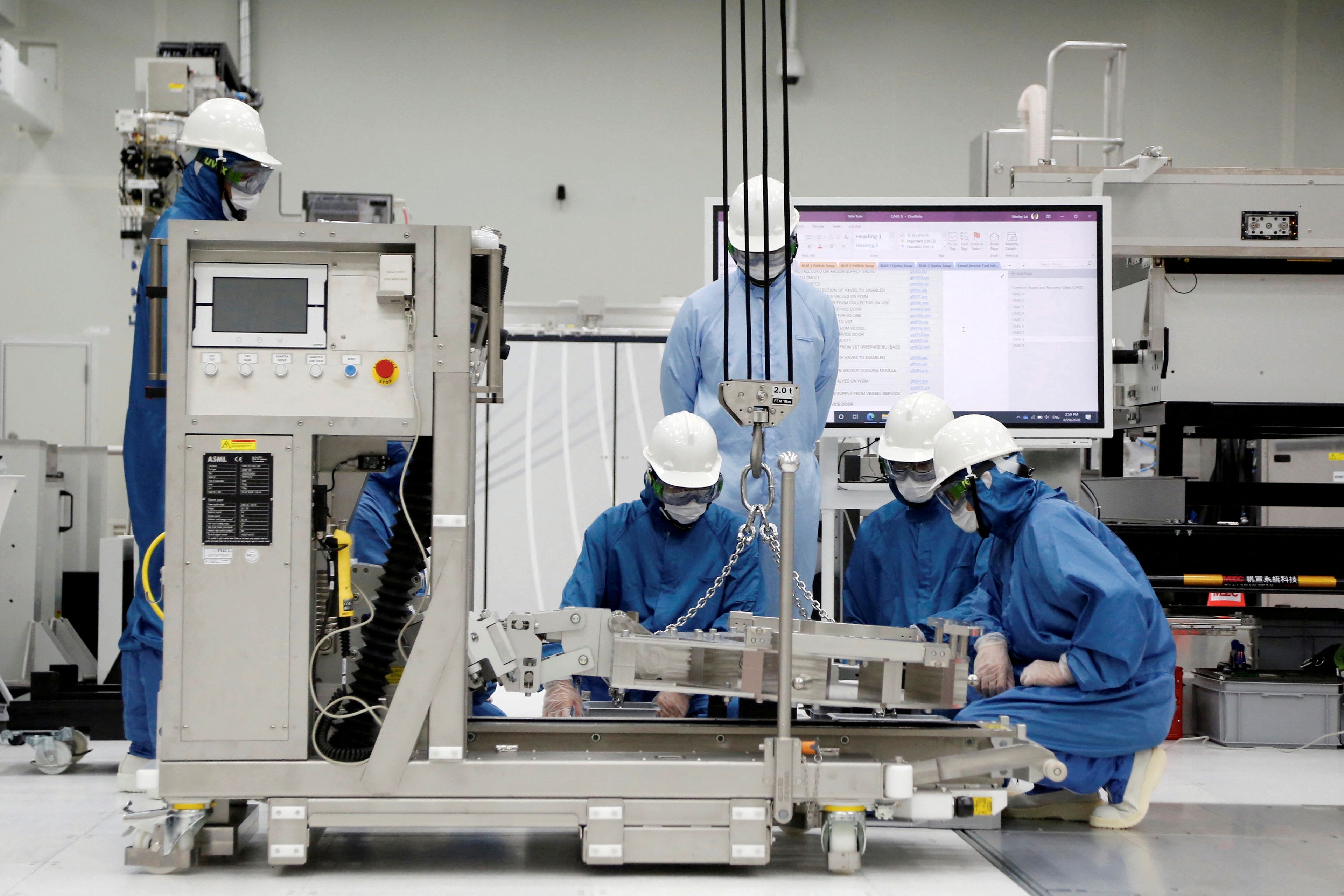 Operarios con una de las máquinas de impresión de chips de la empresa neerlandesa ASML en Taiwán.