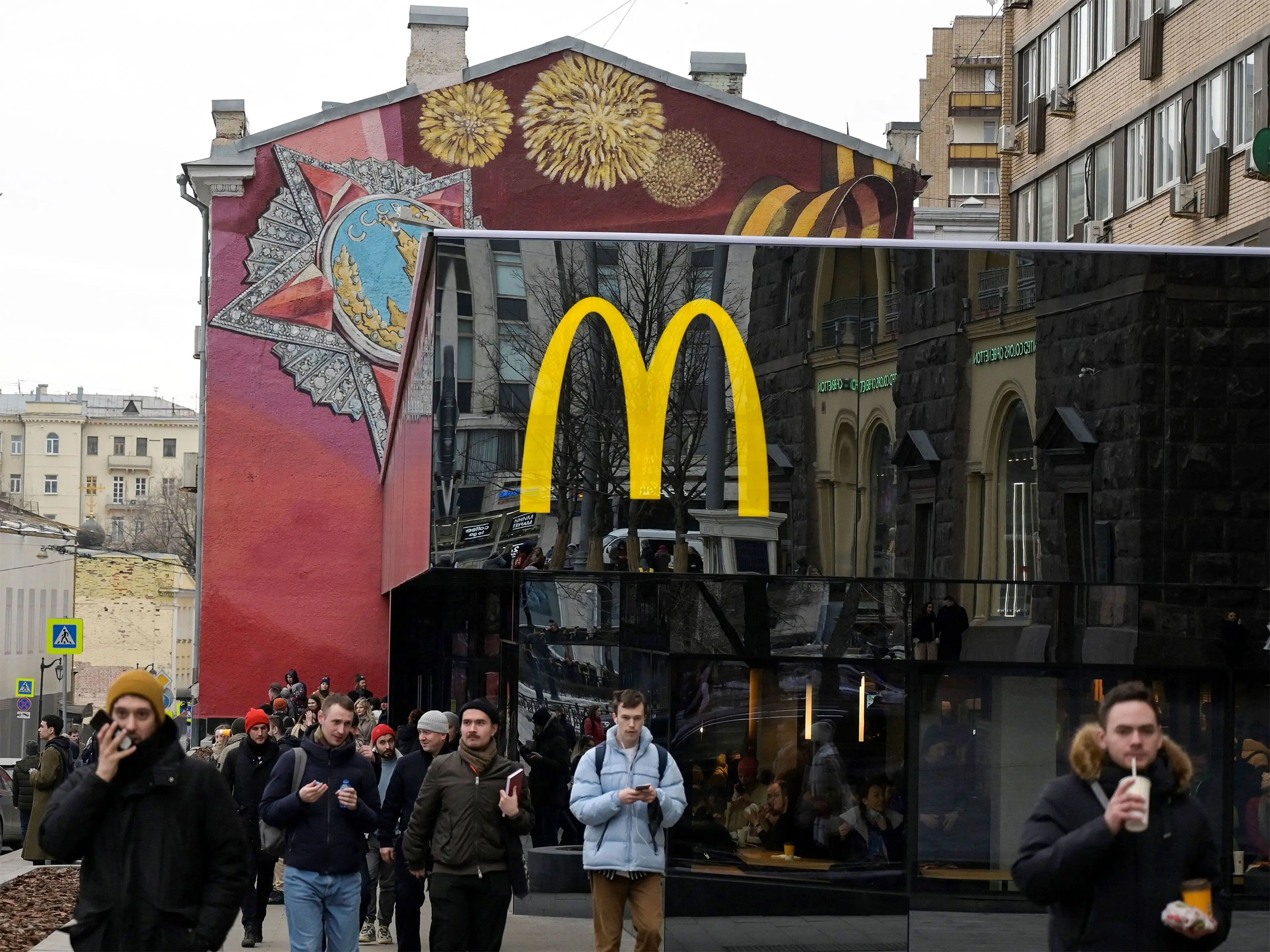 Varias personas caminan frente al restaurante insignia de McDonald's en la plaza Pushkin de Moscú el pasado domingo, último día de la empresa en Rusia.