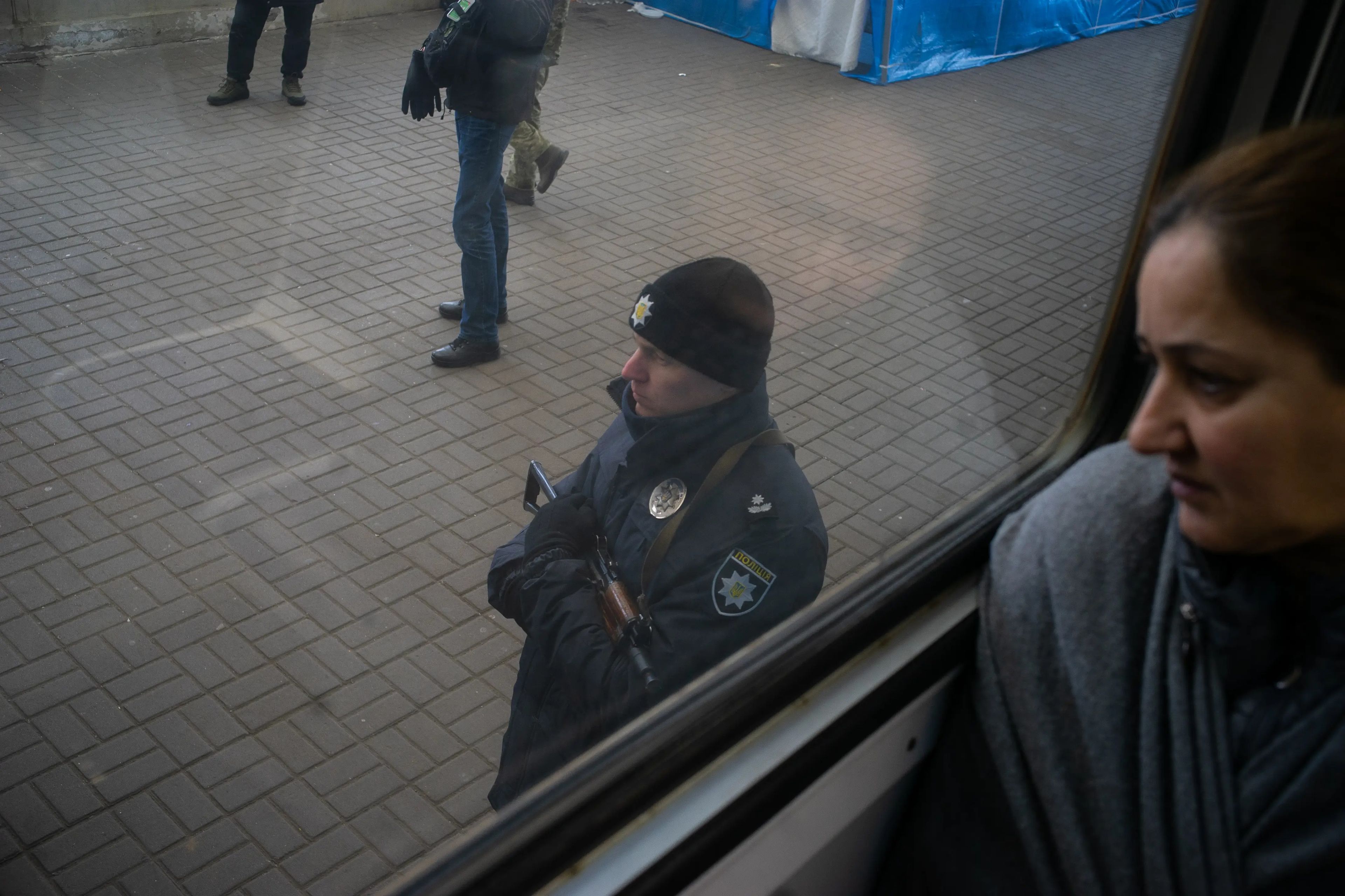 Un policía vigila el andén mientras un tren con destino a Polonia sale de Ucrania repleto de pasajeros.