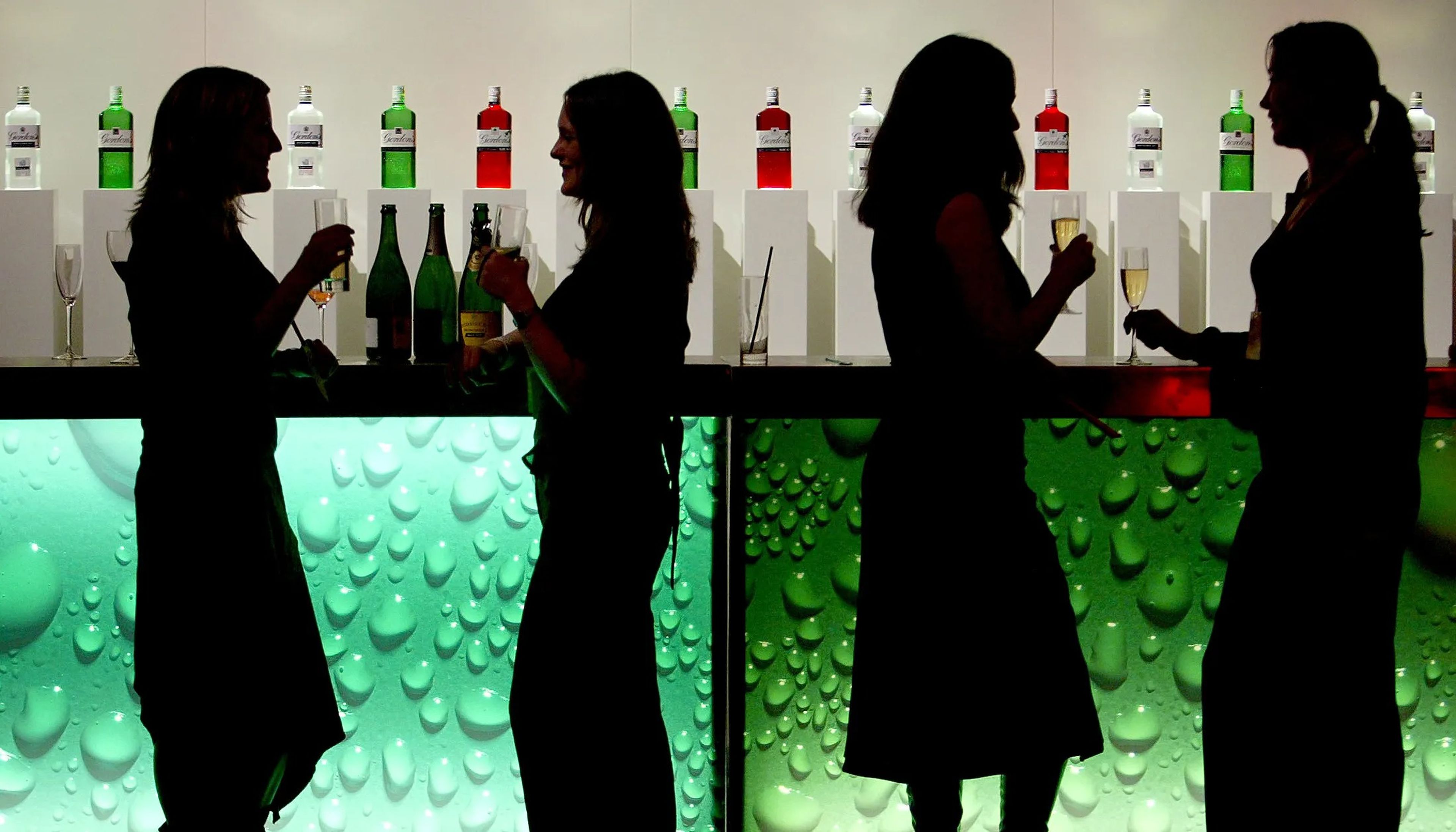 Mujeres bebiendo en la barra de un bar