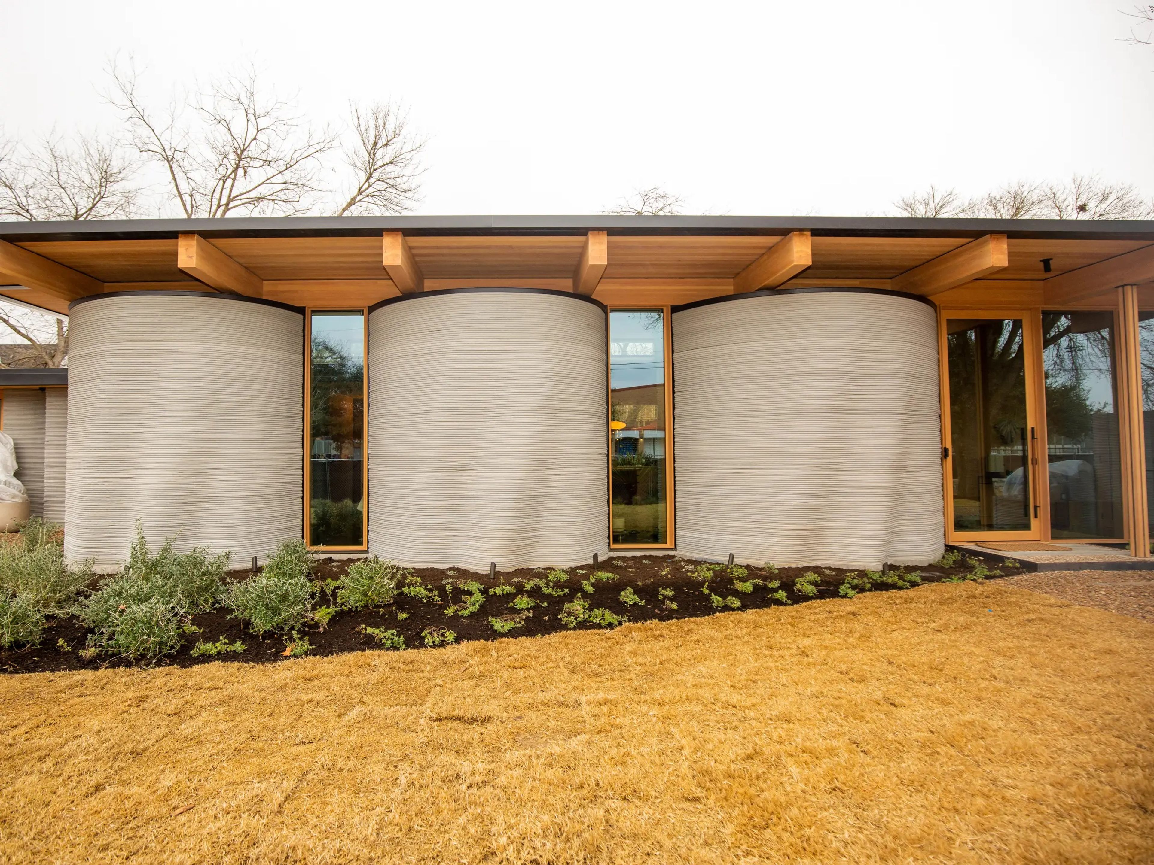 The exterior of Icon's 3D printed House Zero on a cloudy day.