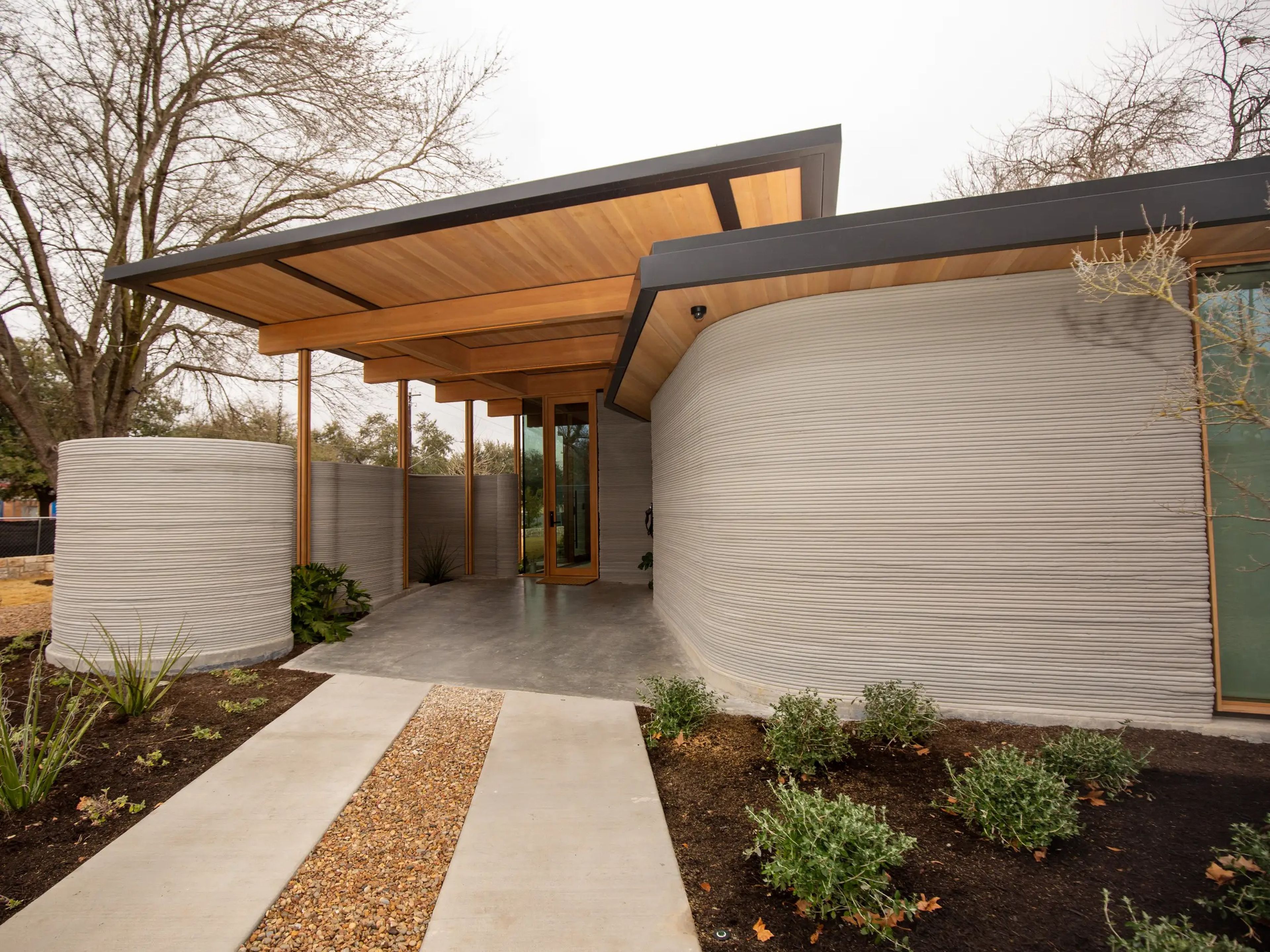 The exterior of Icon's 3D printed House Zero on a cloudy day.