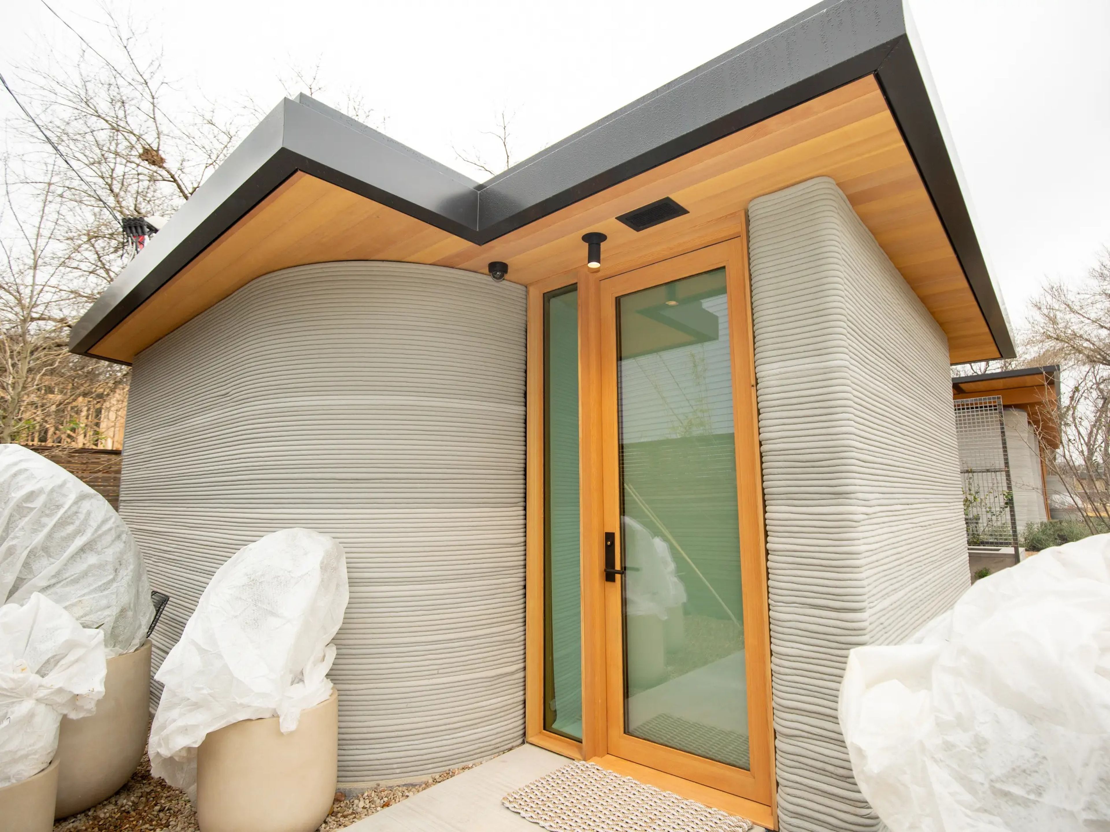 The exterior of Icon's 3D printed House Zero's ADU on a cloudy day.