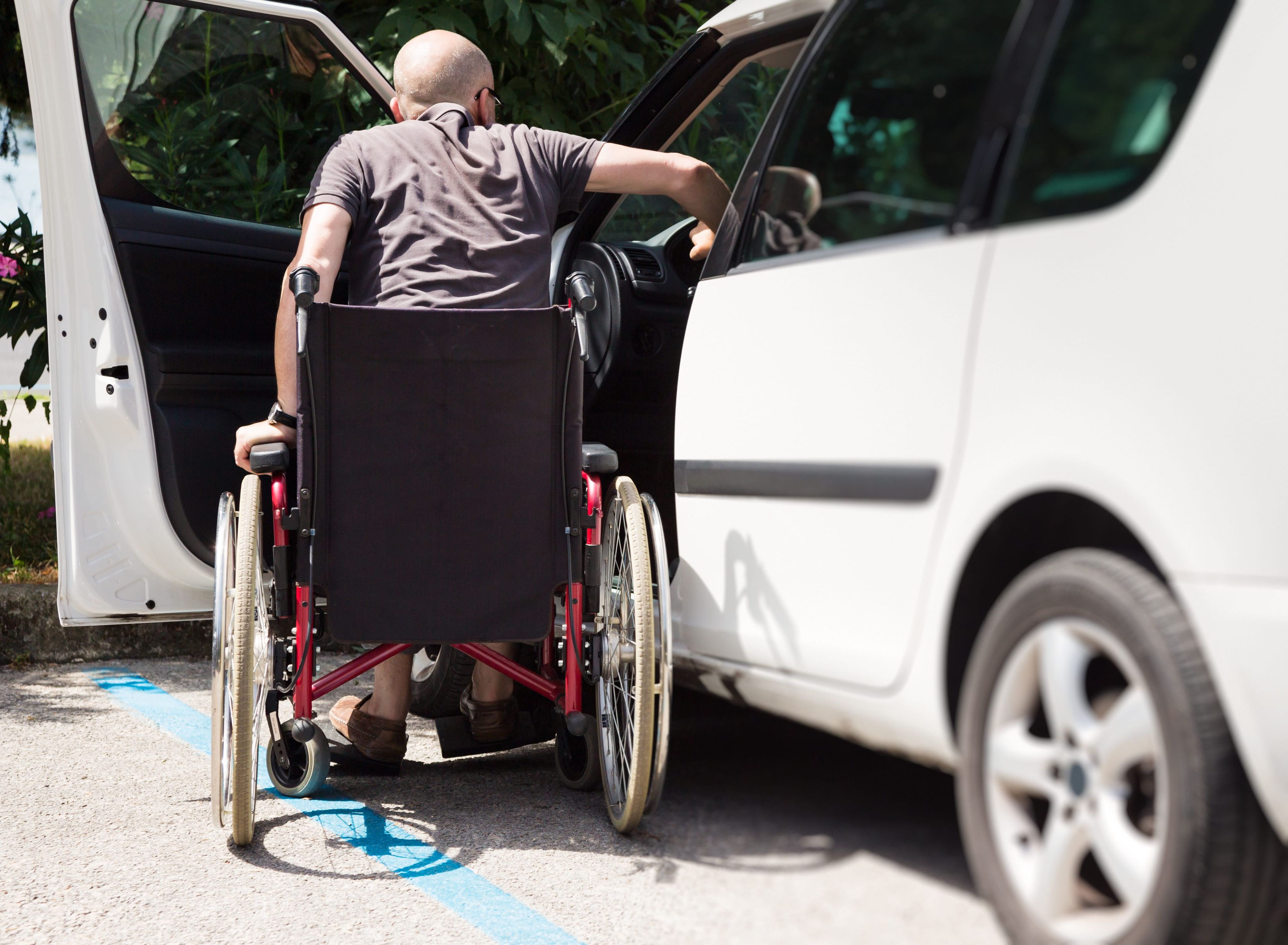 Un hombre con discapacidad entrando en un coche