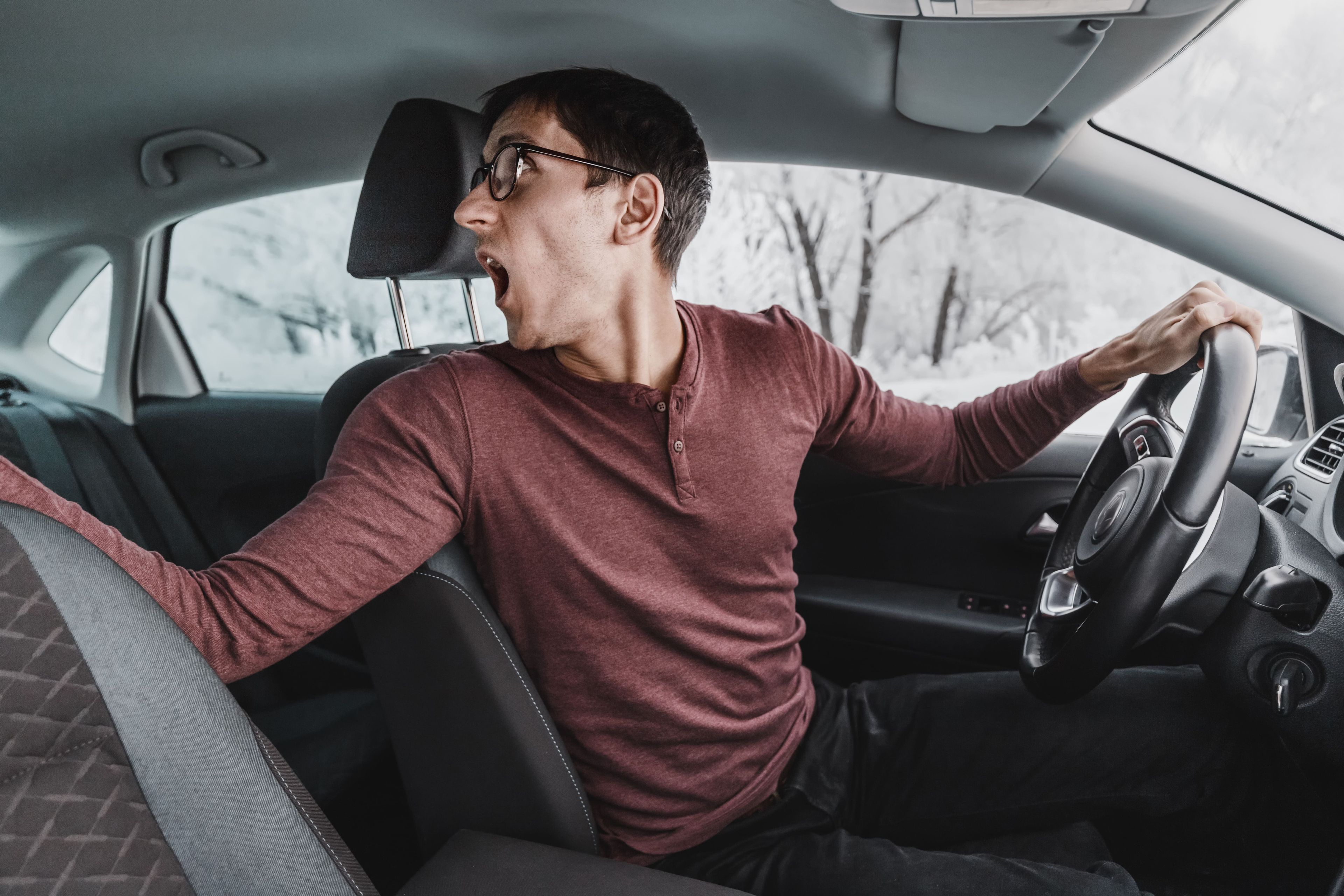Un hombre gritando mientras aparca el coche