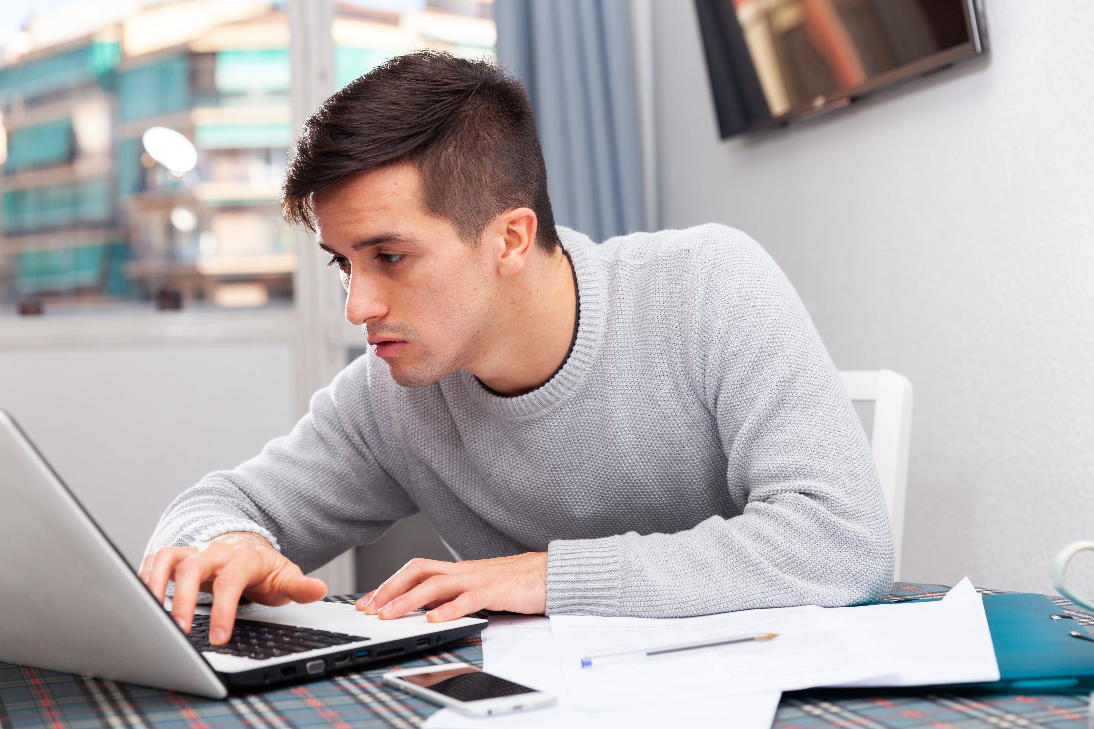 Un hombre joven revisando el ordenador
