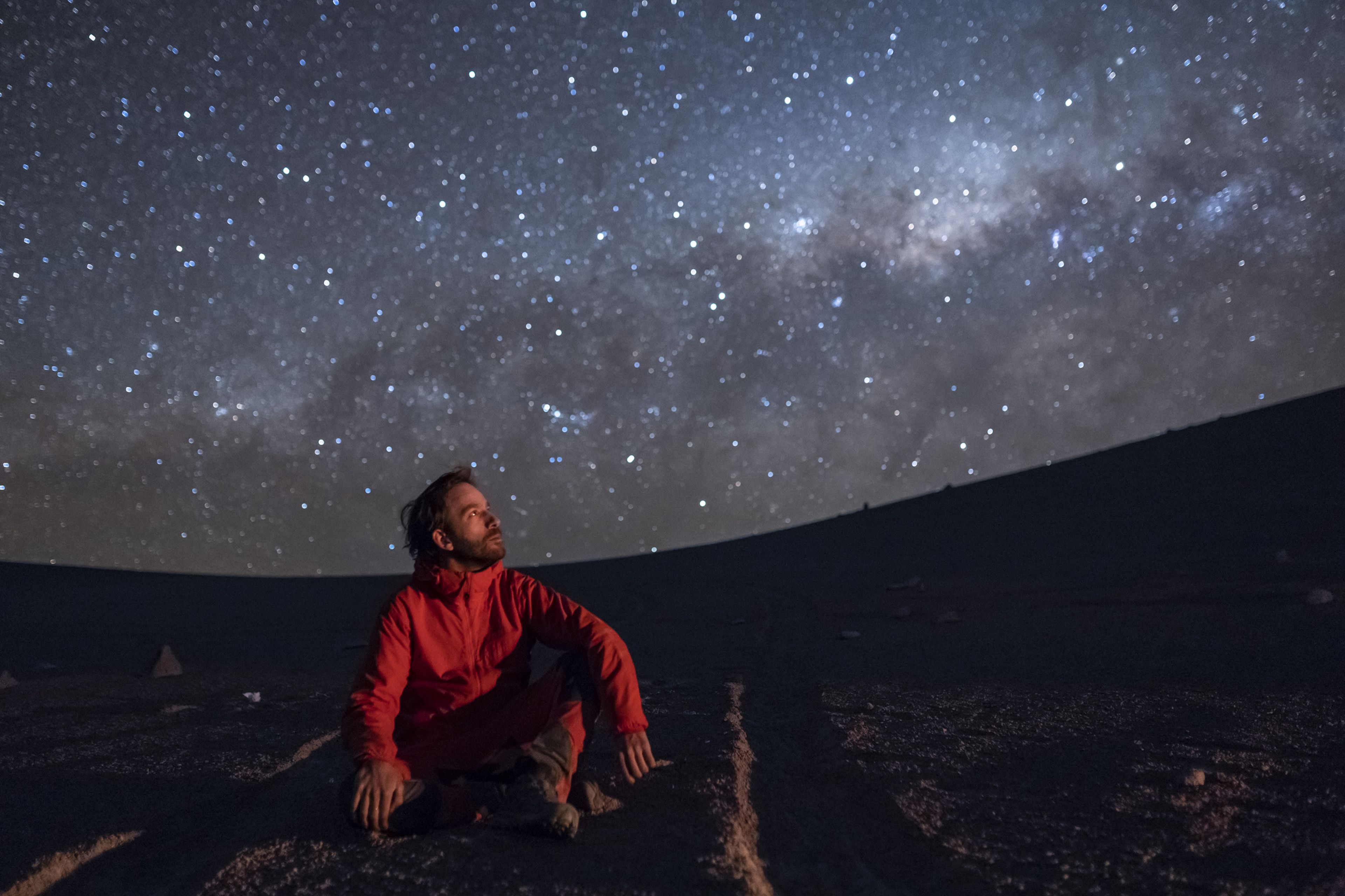 Hombre observando el cielo nocturno con estrellas